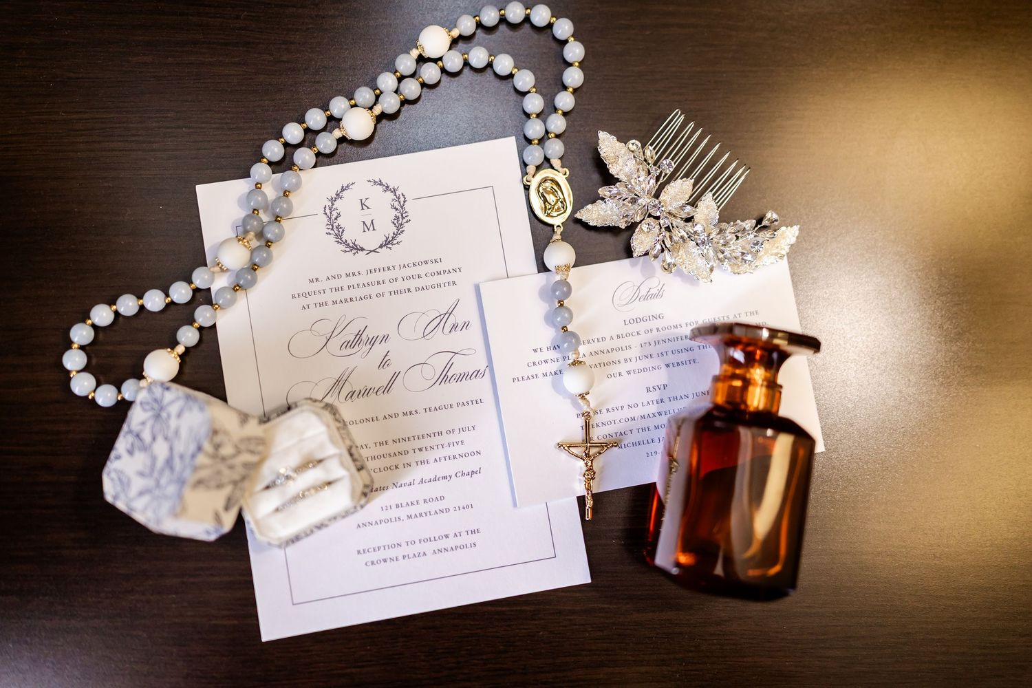 Wedding invitation details with pearls, perfume bottle and delicate paper elements in warm lighting.