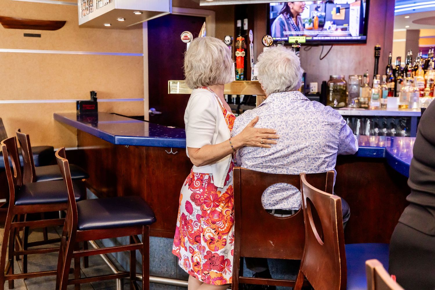 Two people having an intimate conversation at a bar counter.