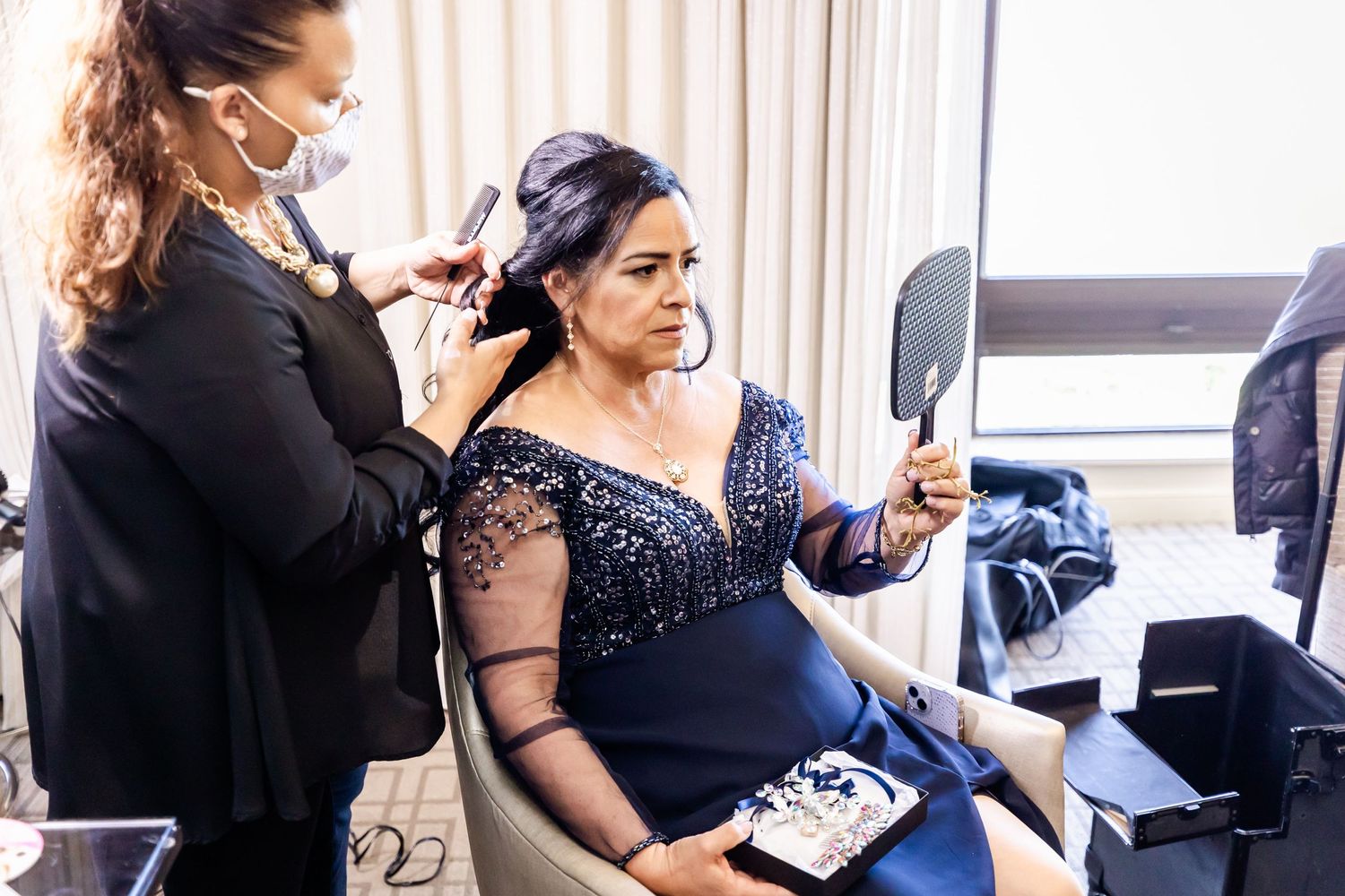 Stylist working on wedding day preparations with professional lighting setup.
