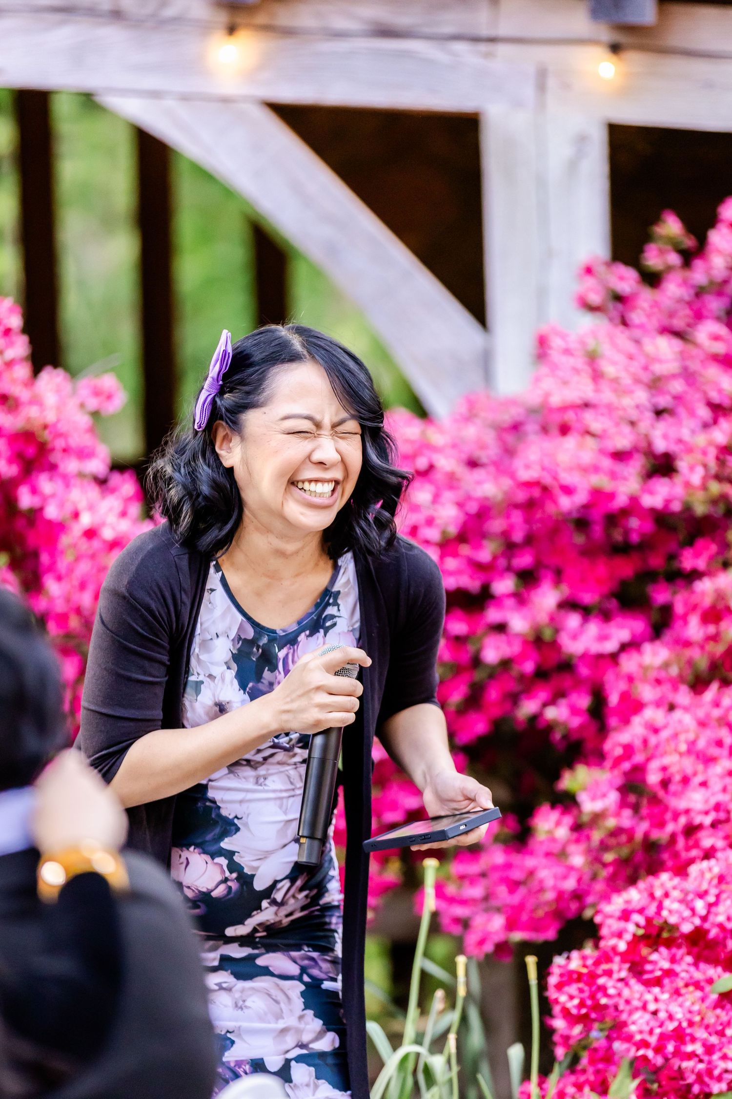 An outdoor celebration with string lights and bright pink azaleas in the background.