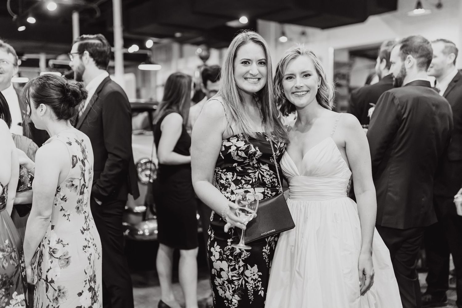 Elegant reception gathering with guests in formal attire at evening event.