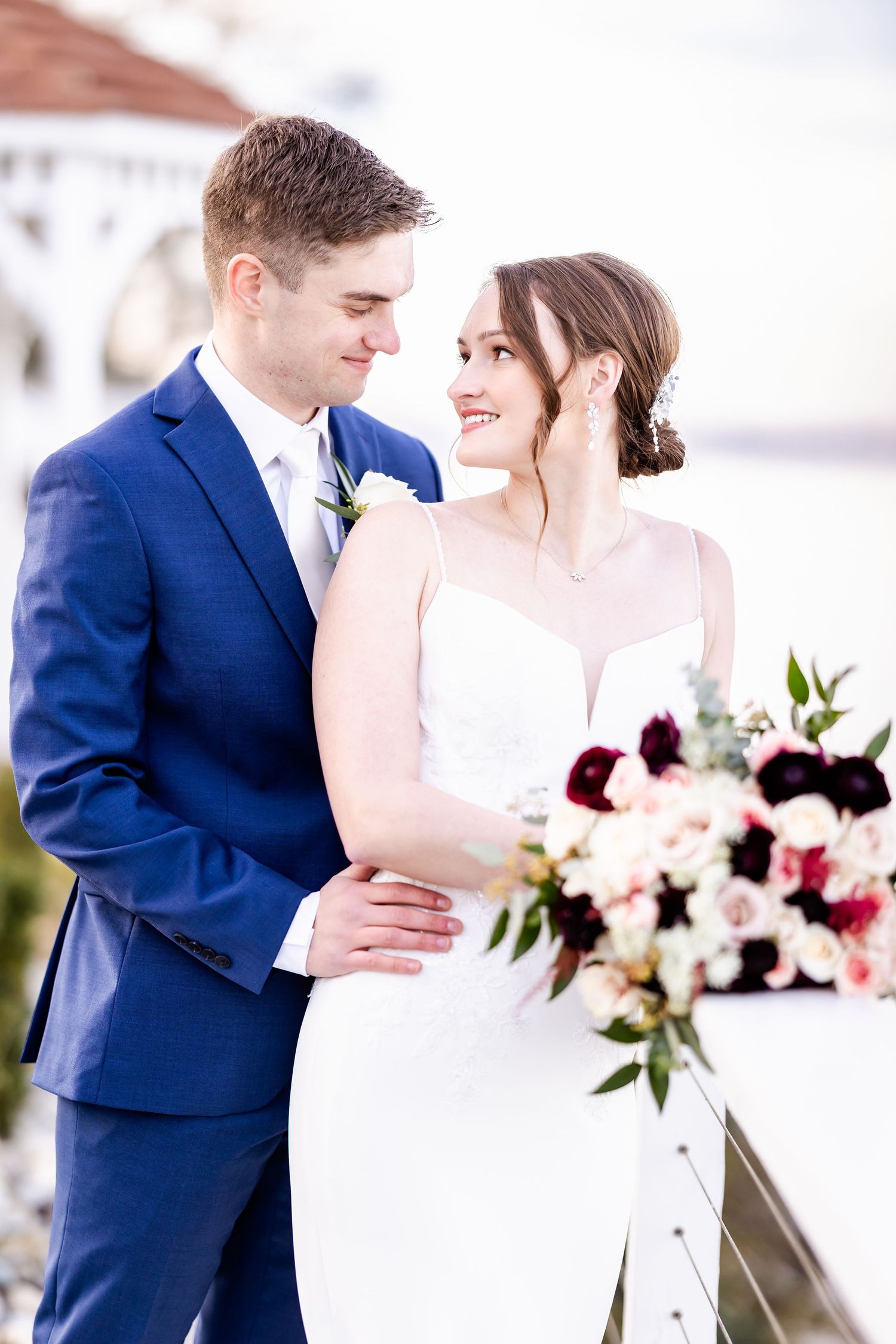 Couple shares romantic moment during wedding portraits in soft natural light.
