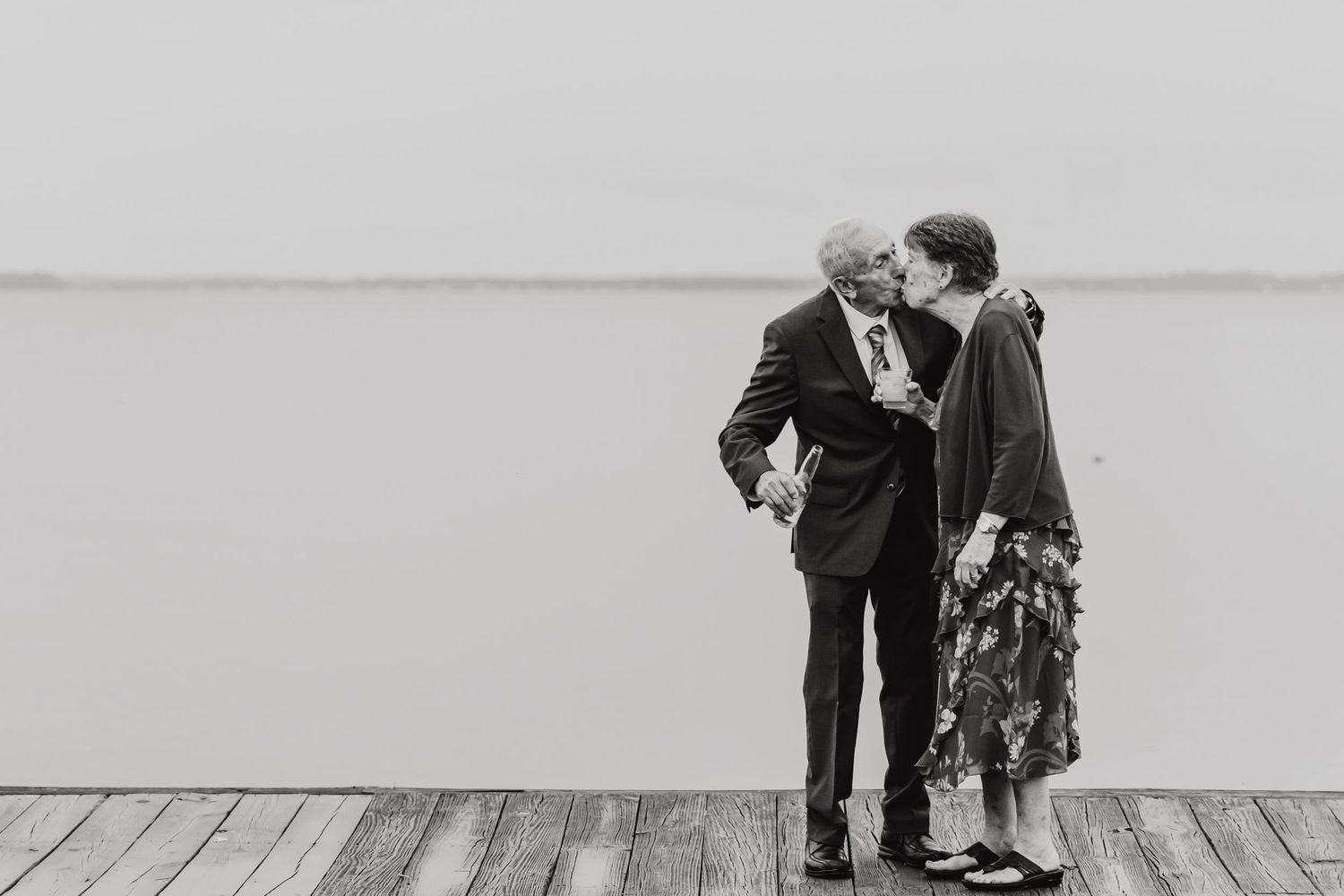 Black and white wedding photos showing intimate moments on a wooden deck.
