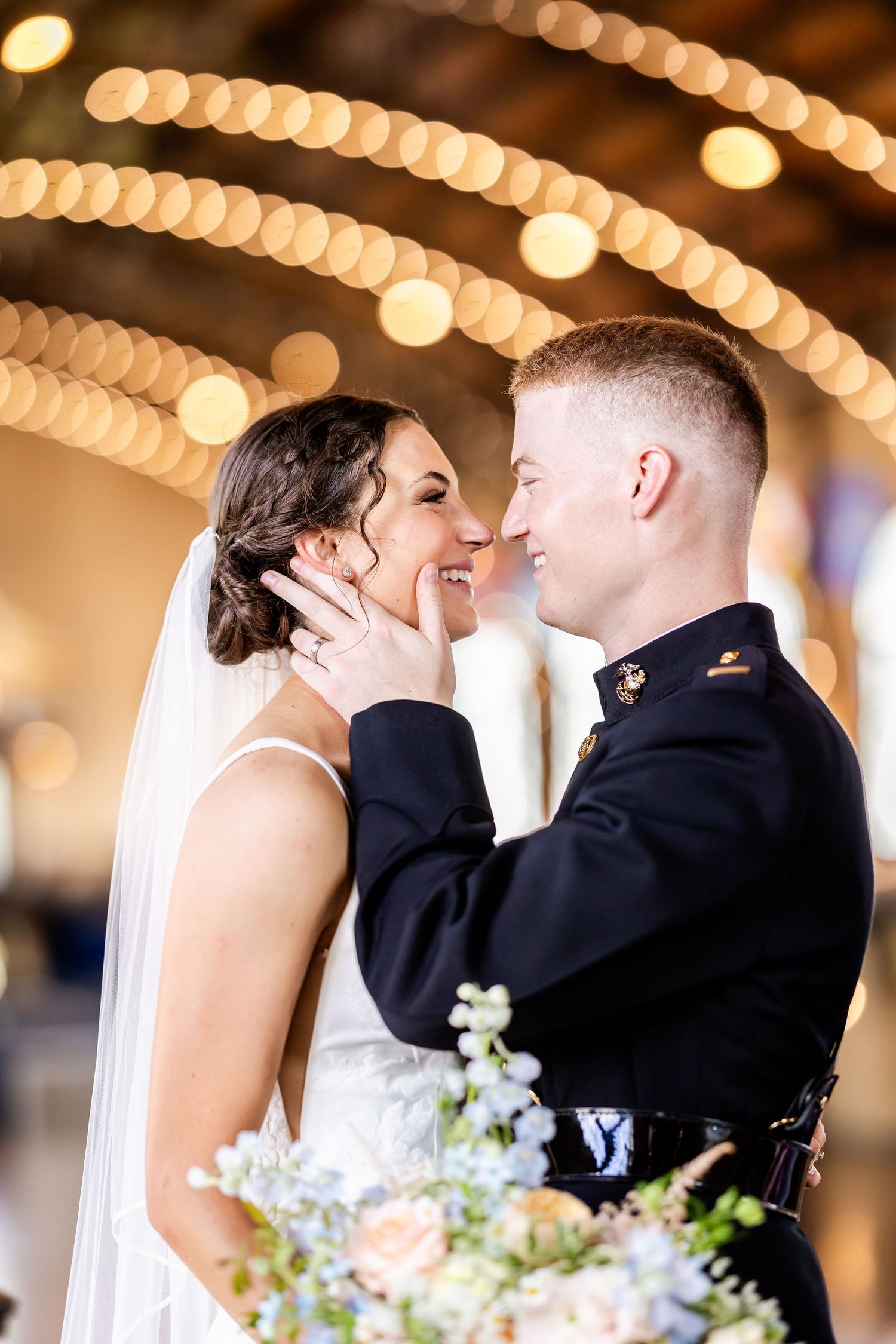 A romantic wedding moment captured with soft bokeh lights in the background and a beautiful floral bouquet.