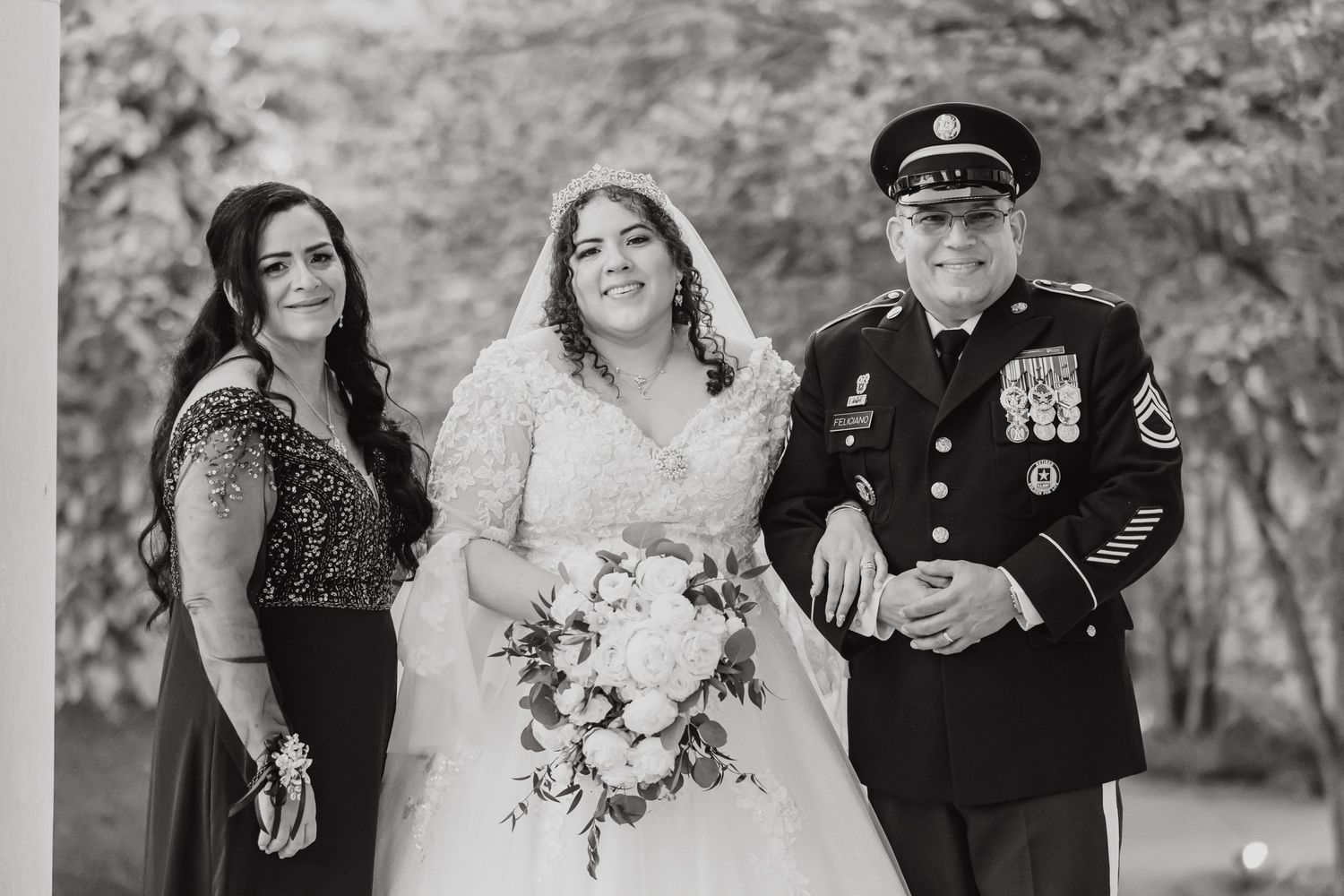 Black and white wedding portrait with formal attire and military dress uniform.