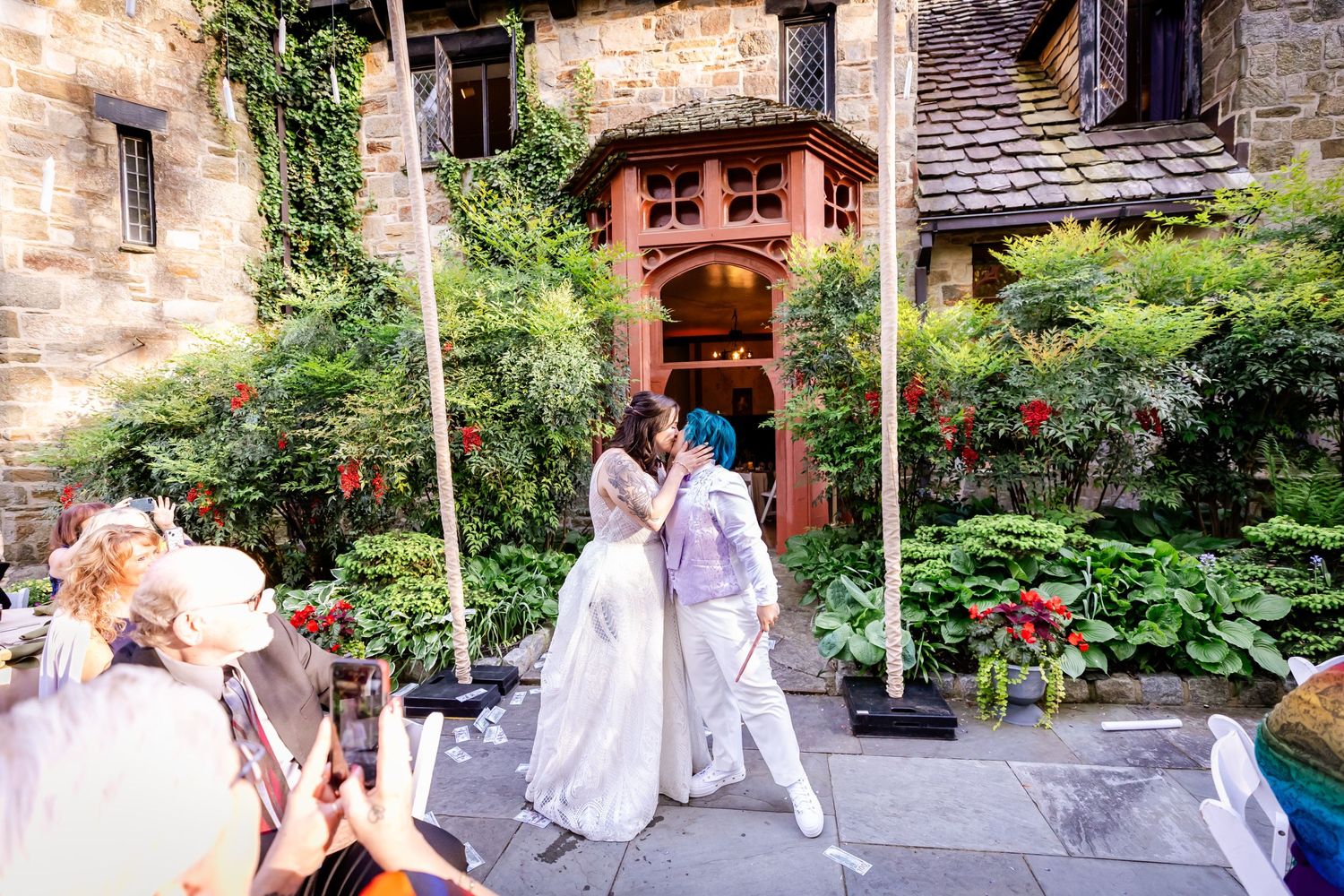 A celebration at an outdoor garden venue with a terracotta archway and red flowers.