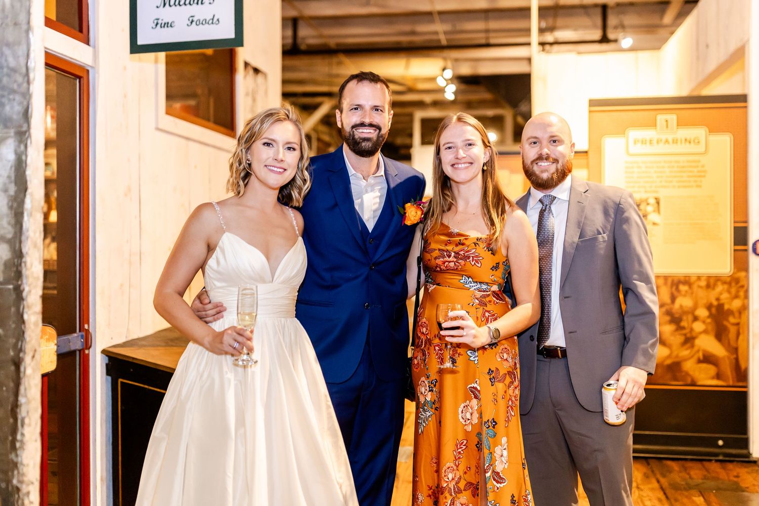 Wedding party poses inside vintage building interior with wooden details.