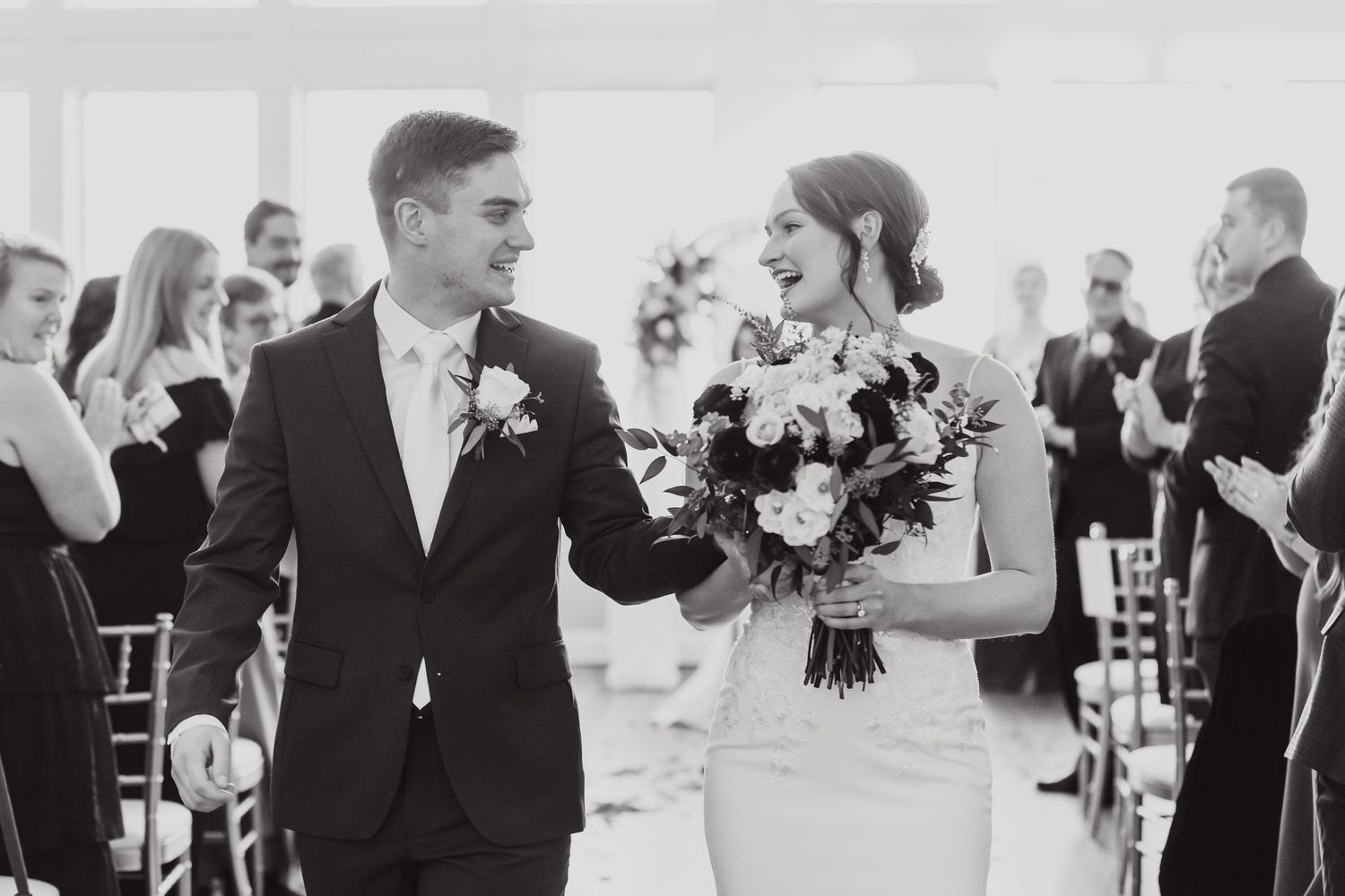 Black and white photos of wedding guests mingling during a reception in an elegant venue.