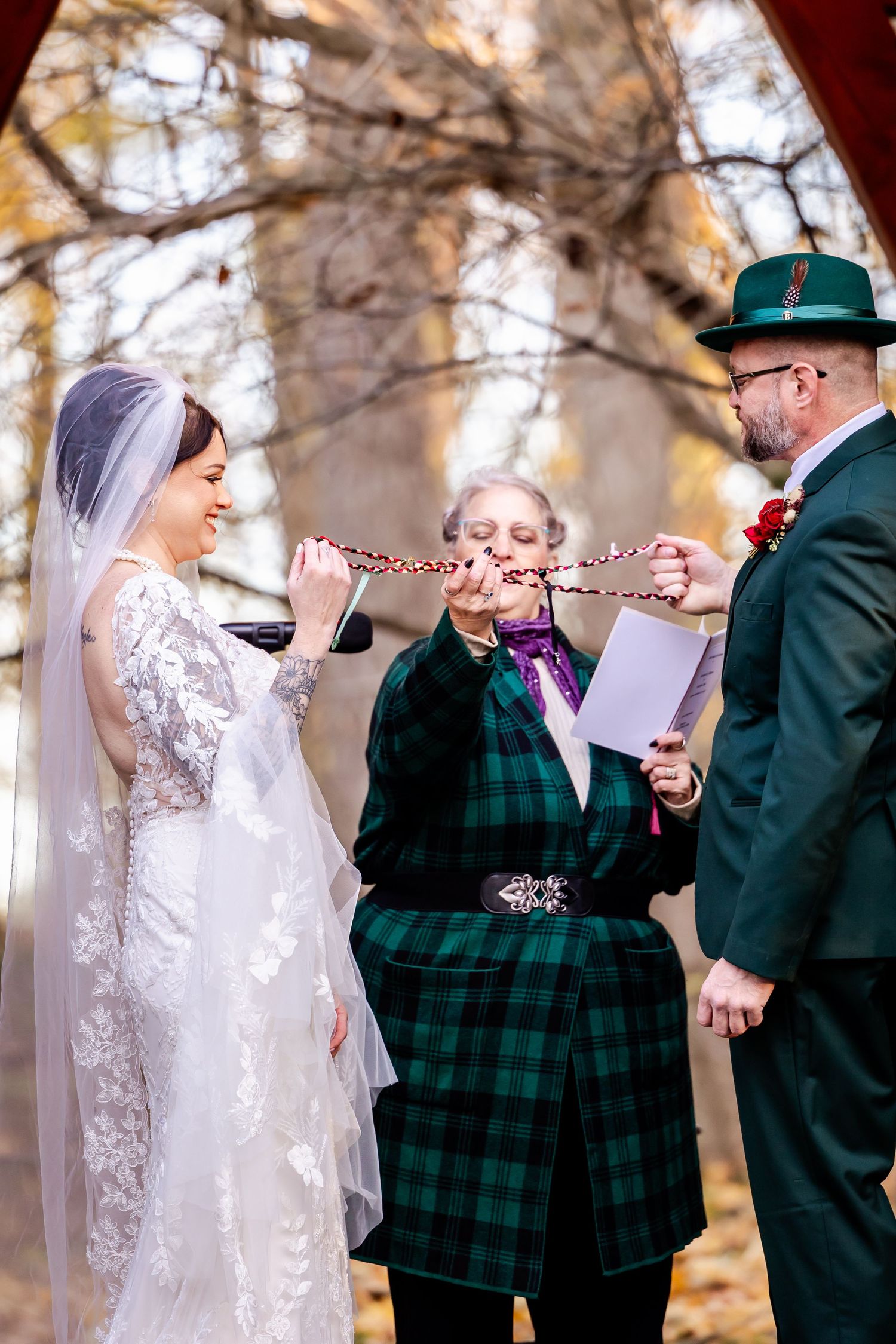 Wedding ceremony moments showing couple exchanging vows under autumn trees.