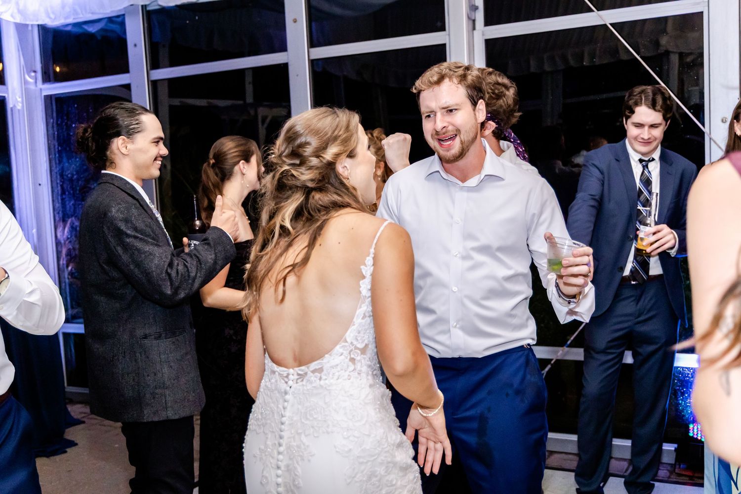 Wedding celebration on dance floor with guests enjoying lively moments.