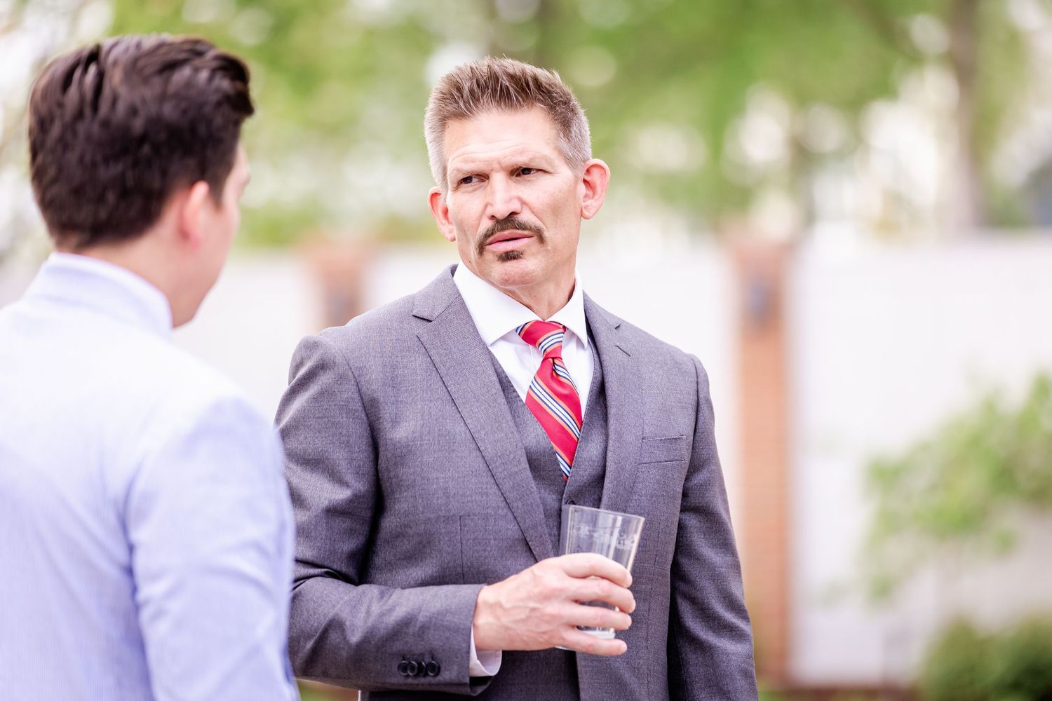Wedding guests mingling during outdoor cocktail hour in formal attire.