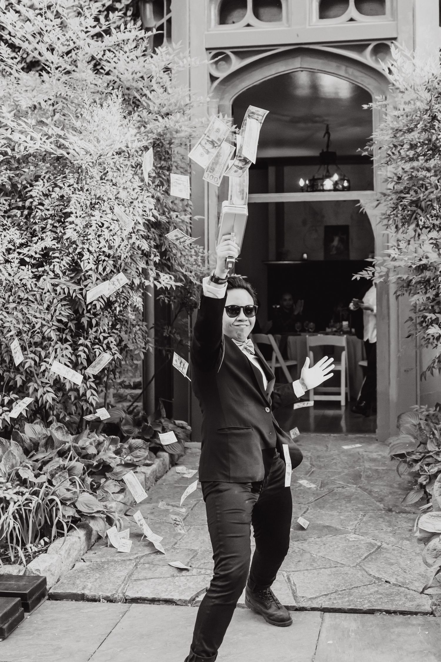 A celebratory moment captured in black and white outside an ornate archway.