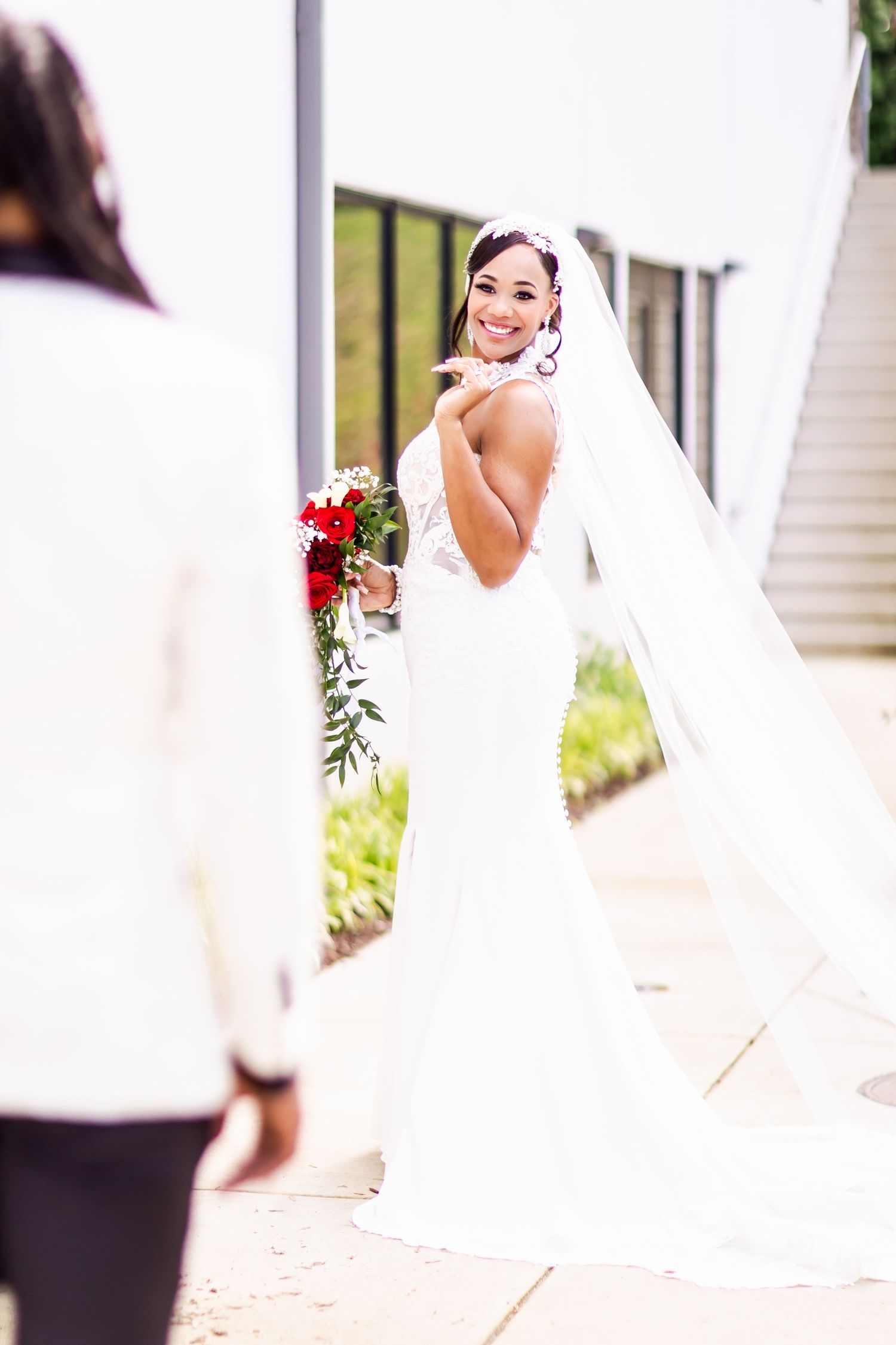 A candid moment of a bride looking over her shoulder with a bright smile.