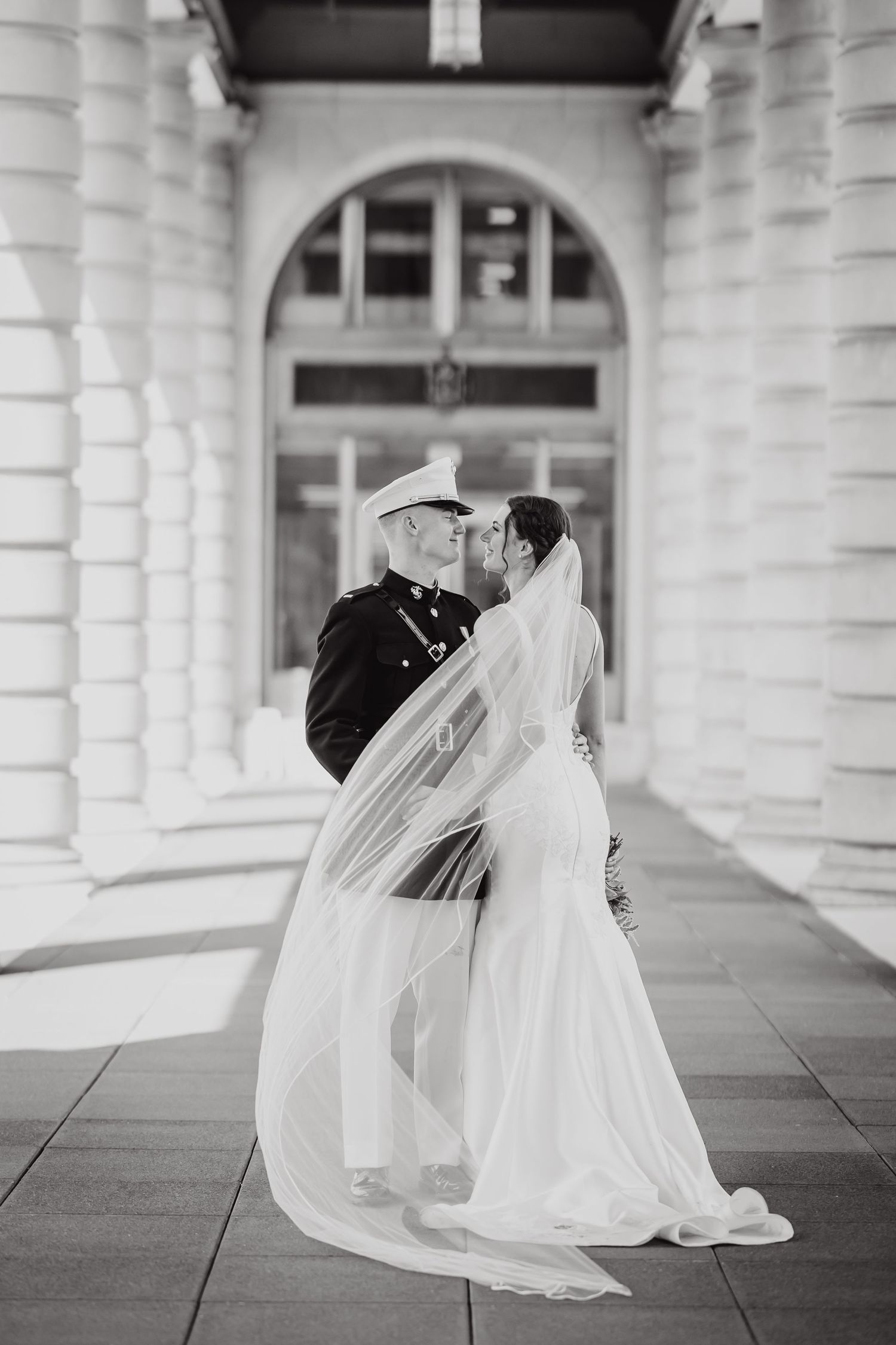 A series of romantic black and white wedding photos captured under an elegant columned archway.