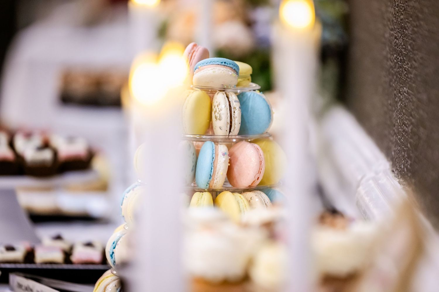 Elegant dessert table with macarons and sweets at wedding reception.