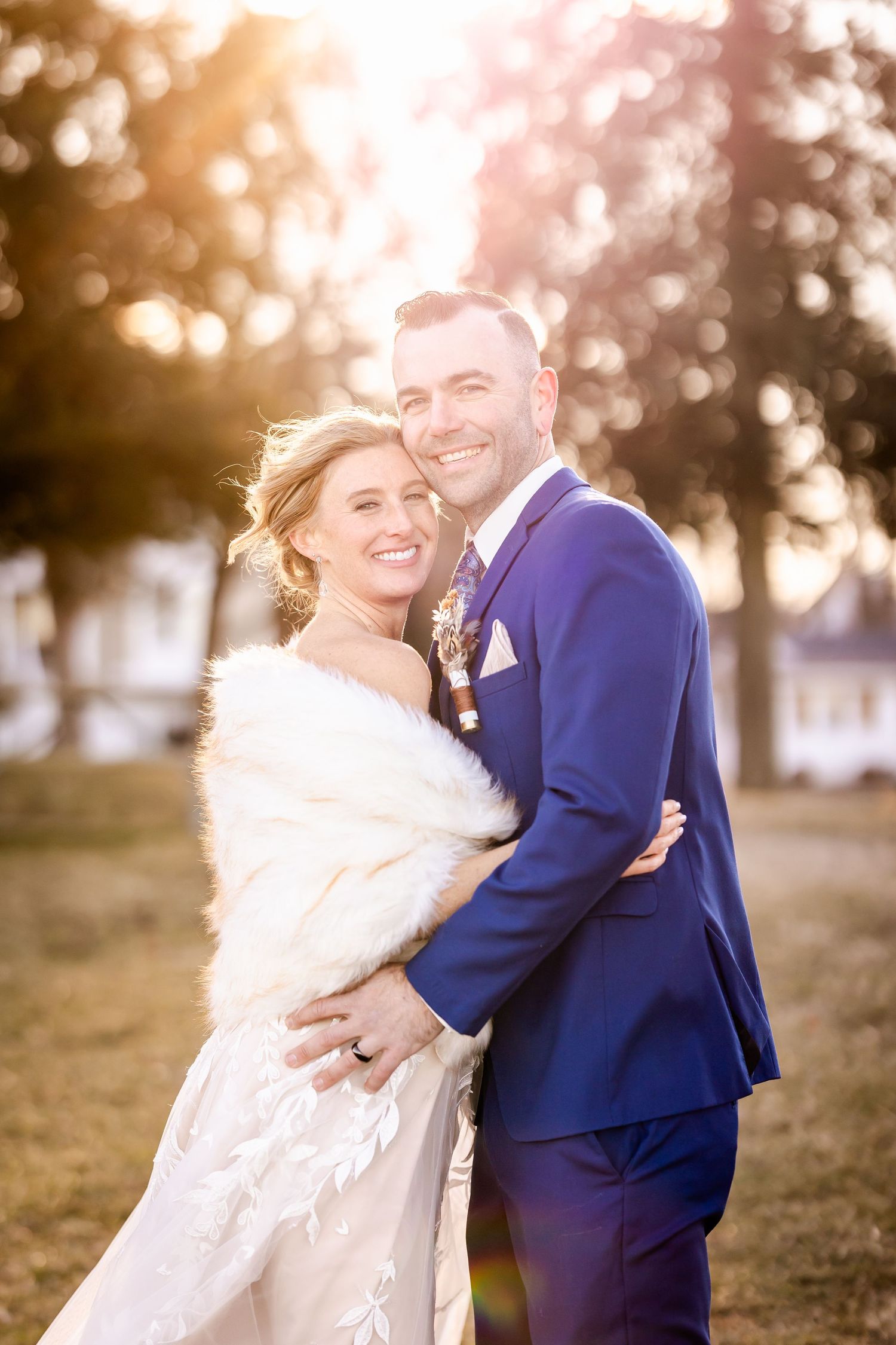 Sunset wedding portrait featuring couple embracing outdoors with golden bokeh background.