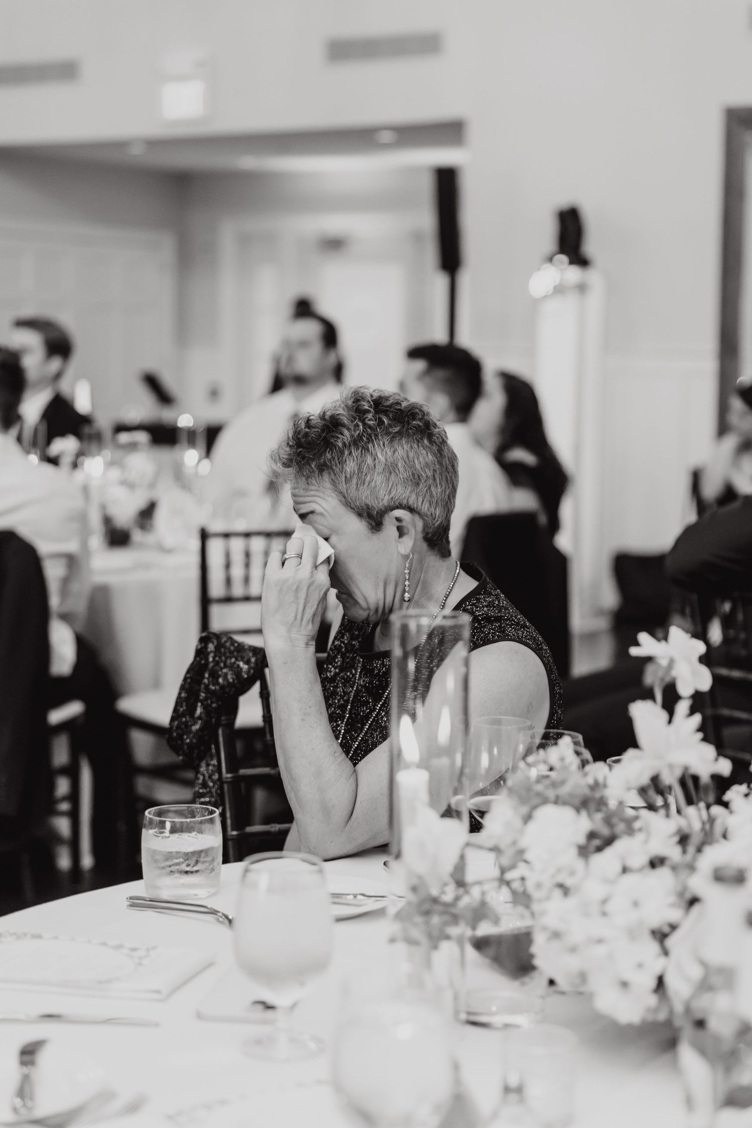 Elegant table settings with white floral centerpieces at a formal wedding reception.