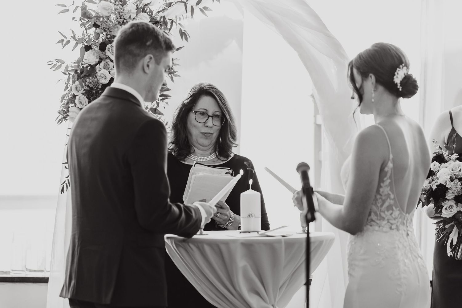 Black and white photo showing a wedding ceremony with guests seated in rows.