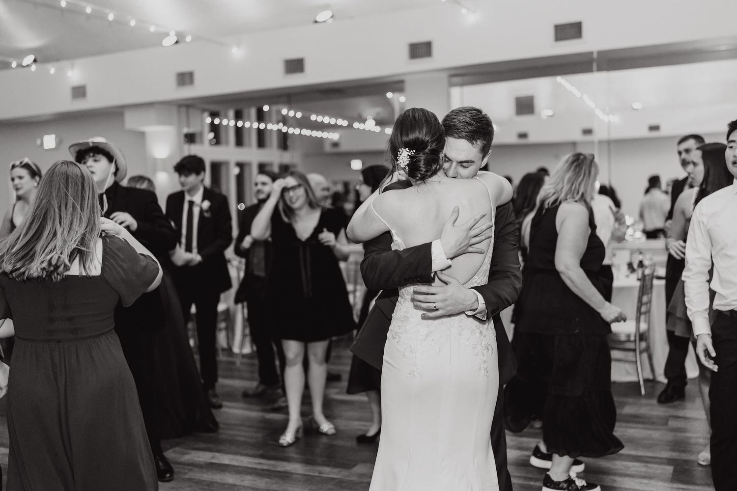 Black and white photos of wedding guests dancing and celebrating at reception.