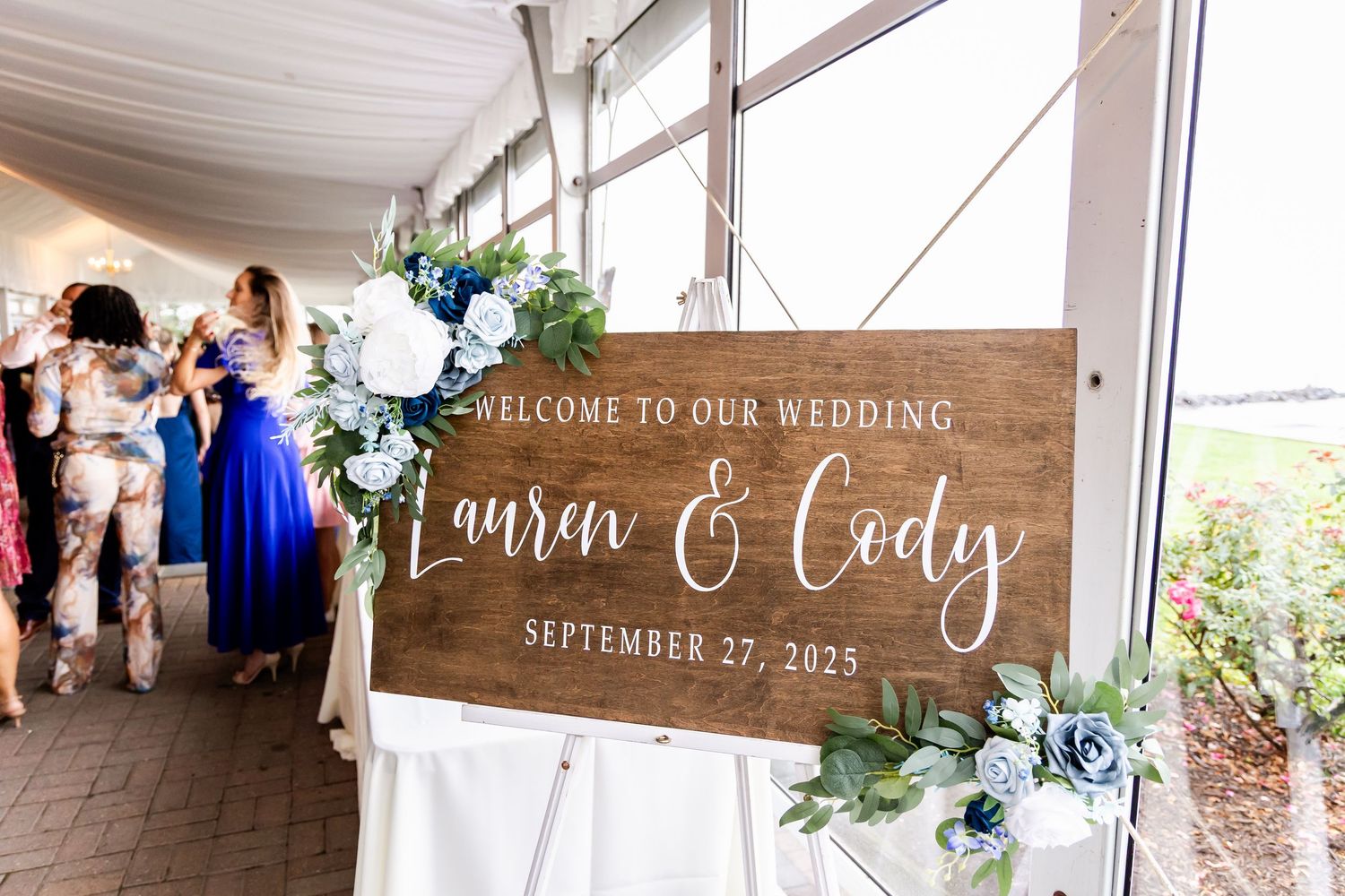 Rustic wooden wedding welcome signs and decor displayed at venue entrance.