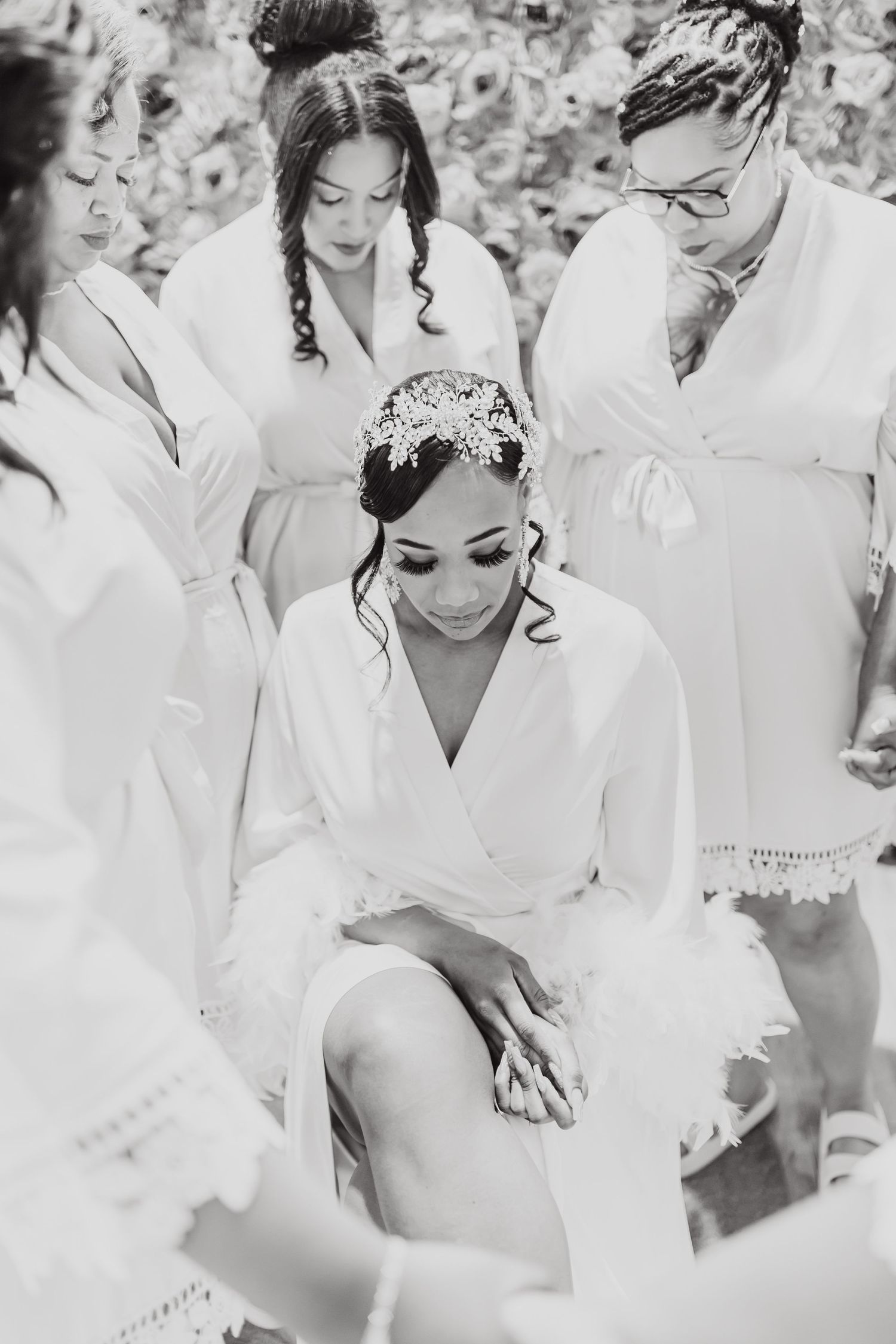 Black and white photo of wedding party getting ready in matching white robes.