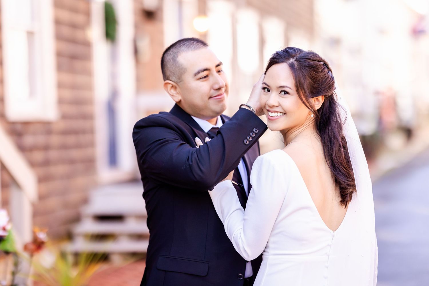 Wedding couple shares intimate moment together against brick wall.