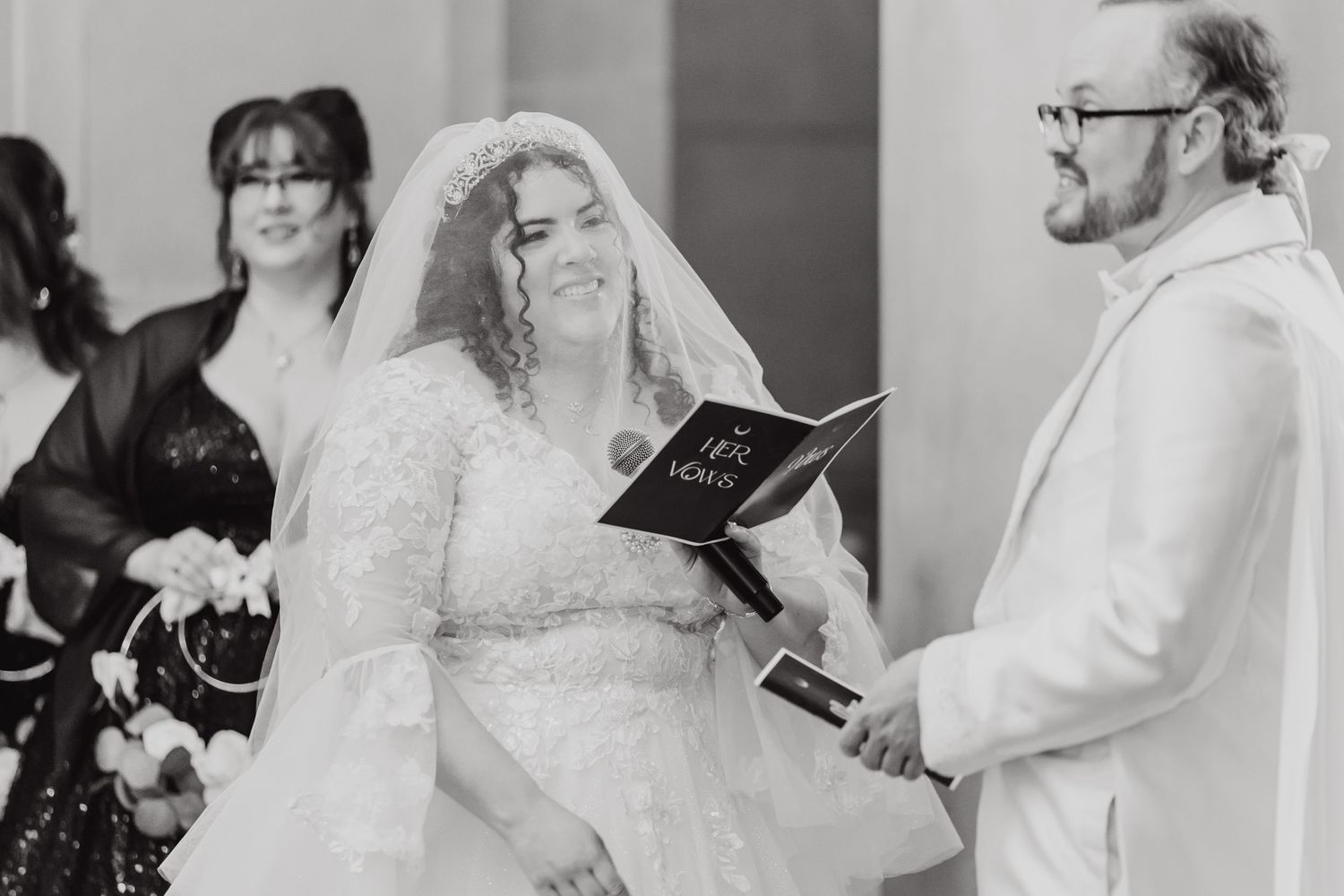 Black and white image of a wedding ceremony with participants holding service books.