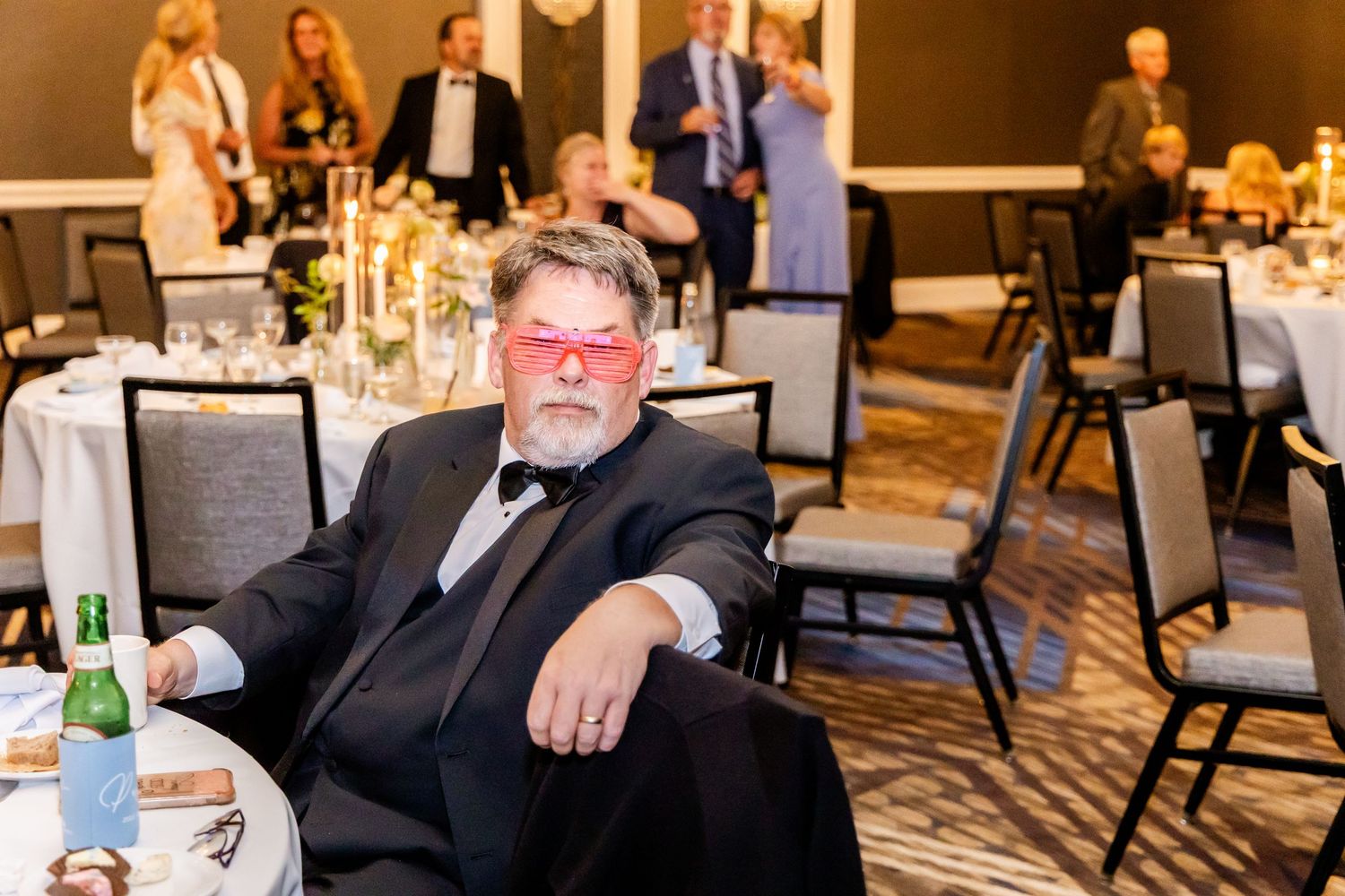 Guests seated at formal dining tables during an elegant indoor event reception.