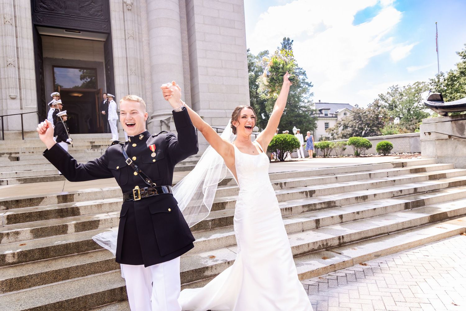 A military service member and bride celebrate joyfully on the church steps after their wedding ceremony.