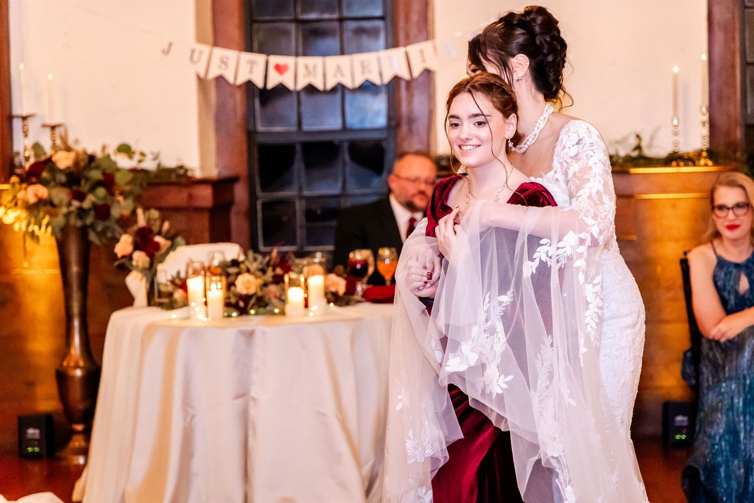 Wedding guests celebrating on a dance floor in an elegant venue with peach-colored walls.