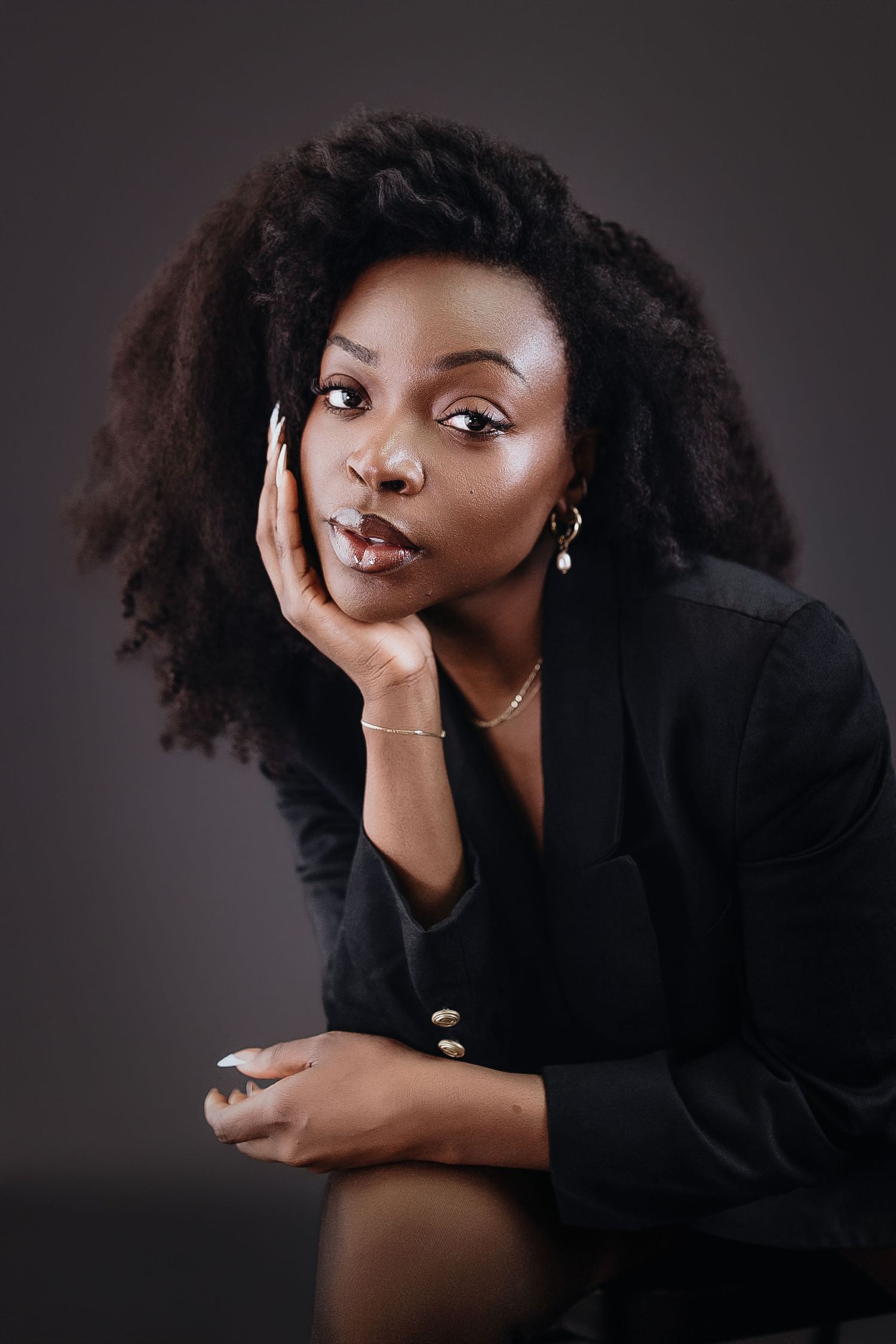 Artistic portrait series of a model in black clothing striking expressive poses against dark background.