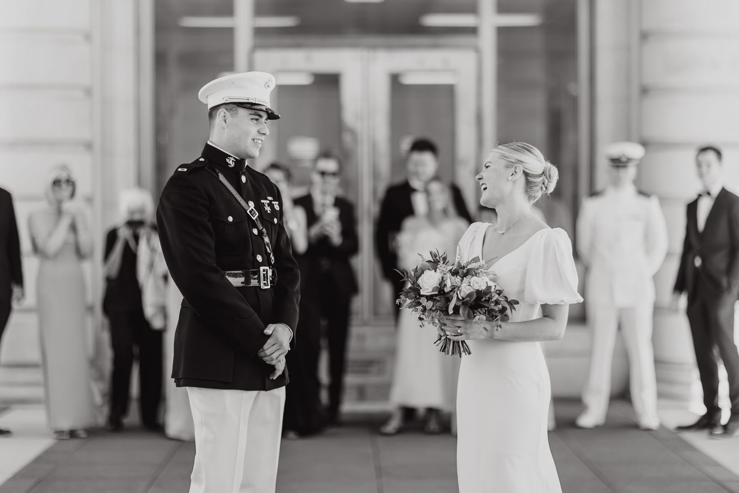 Military wedding ceremony with guests and wedding party in formal attire.