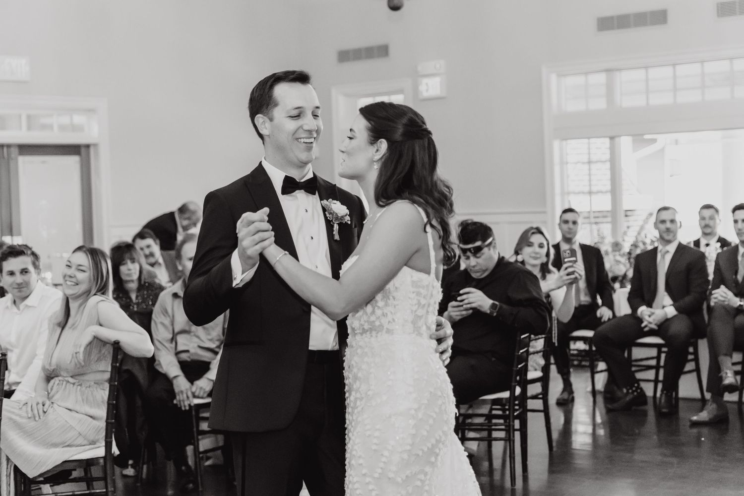 Wedding reception dance party with guests celebrating in formal attire.