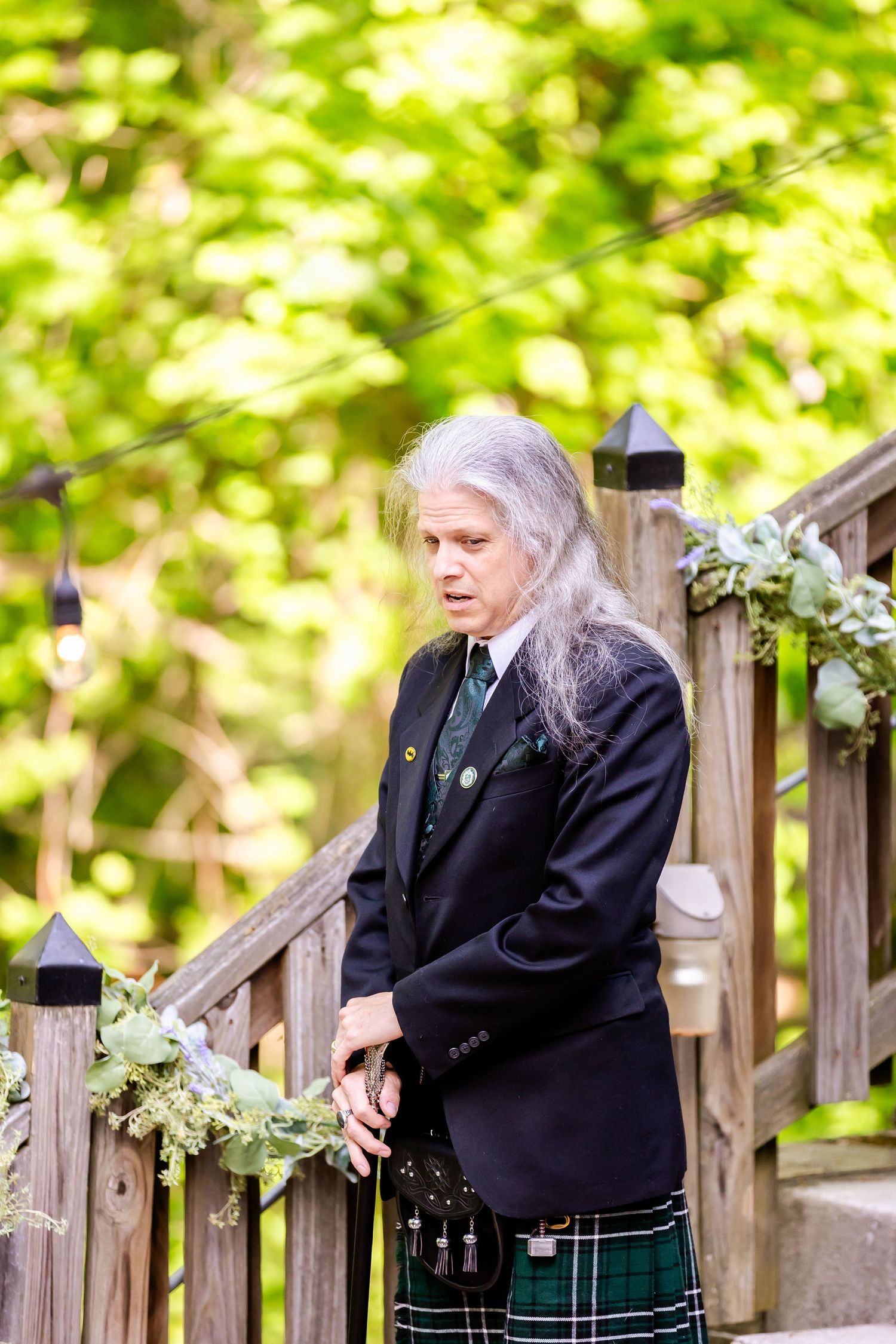 Traditional Scottish attire worn at outdoor garden wedding ceremony.