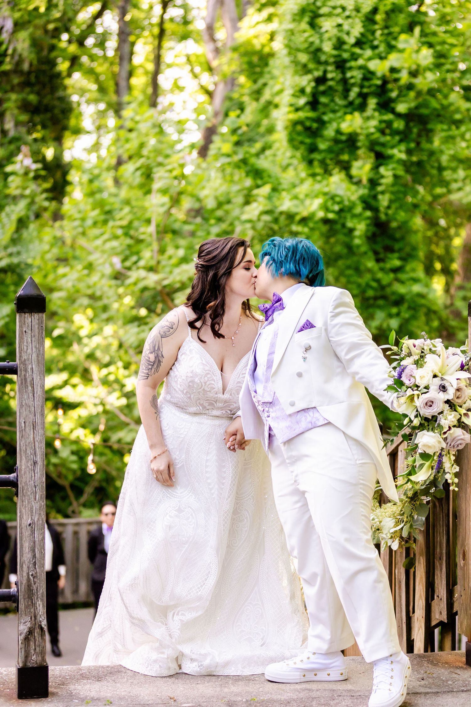 A romantic wedding moment captured on a wooden deck surrounded by lush greenery.