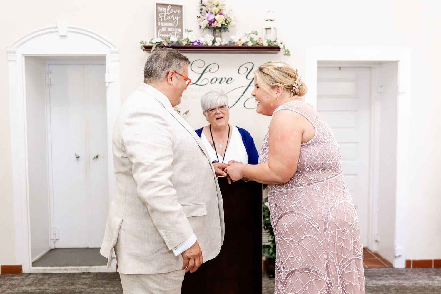 An intimate wedding ceremony in progress under a decorative love sign.