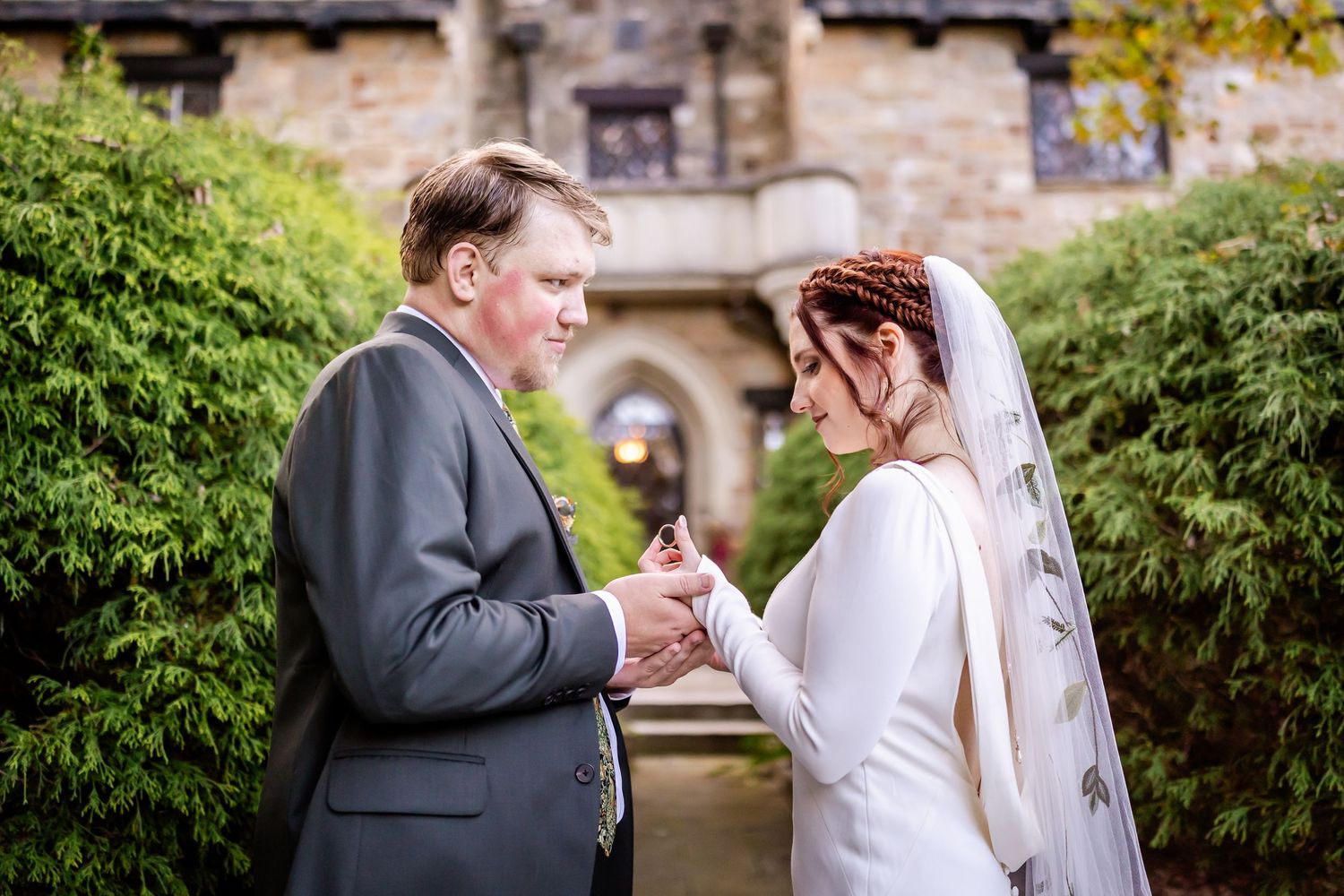 A couple in wedding attire share an intimate moment together in a garden setting during their special day.