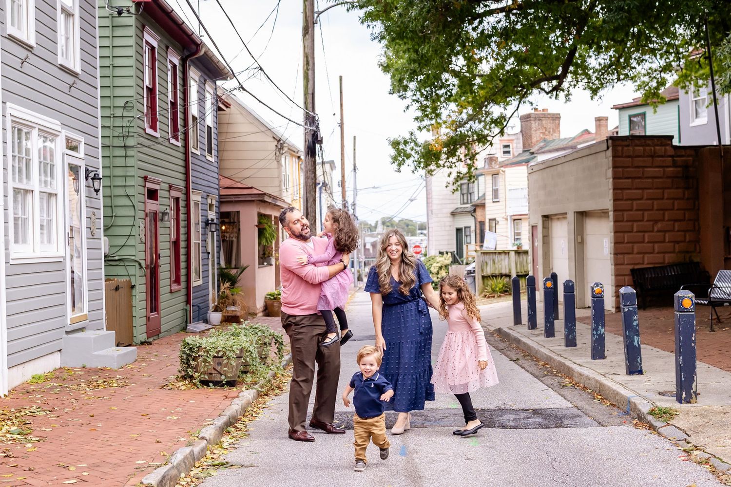People walk along a historic cobblestone street lined with colonial buildings in Annapolis, Maryland.