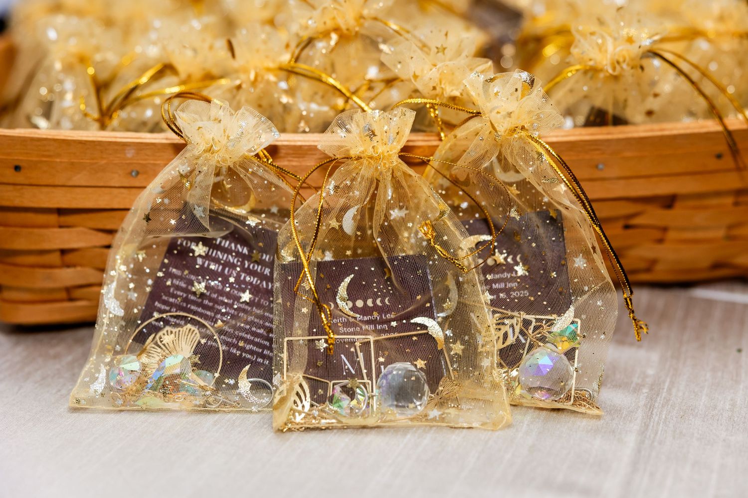 Wedding favor bags with gold ribbon arranged in a wooden basket.