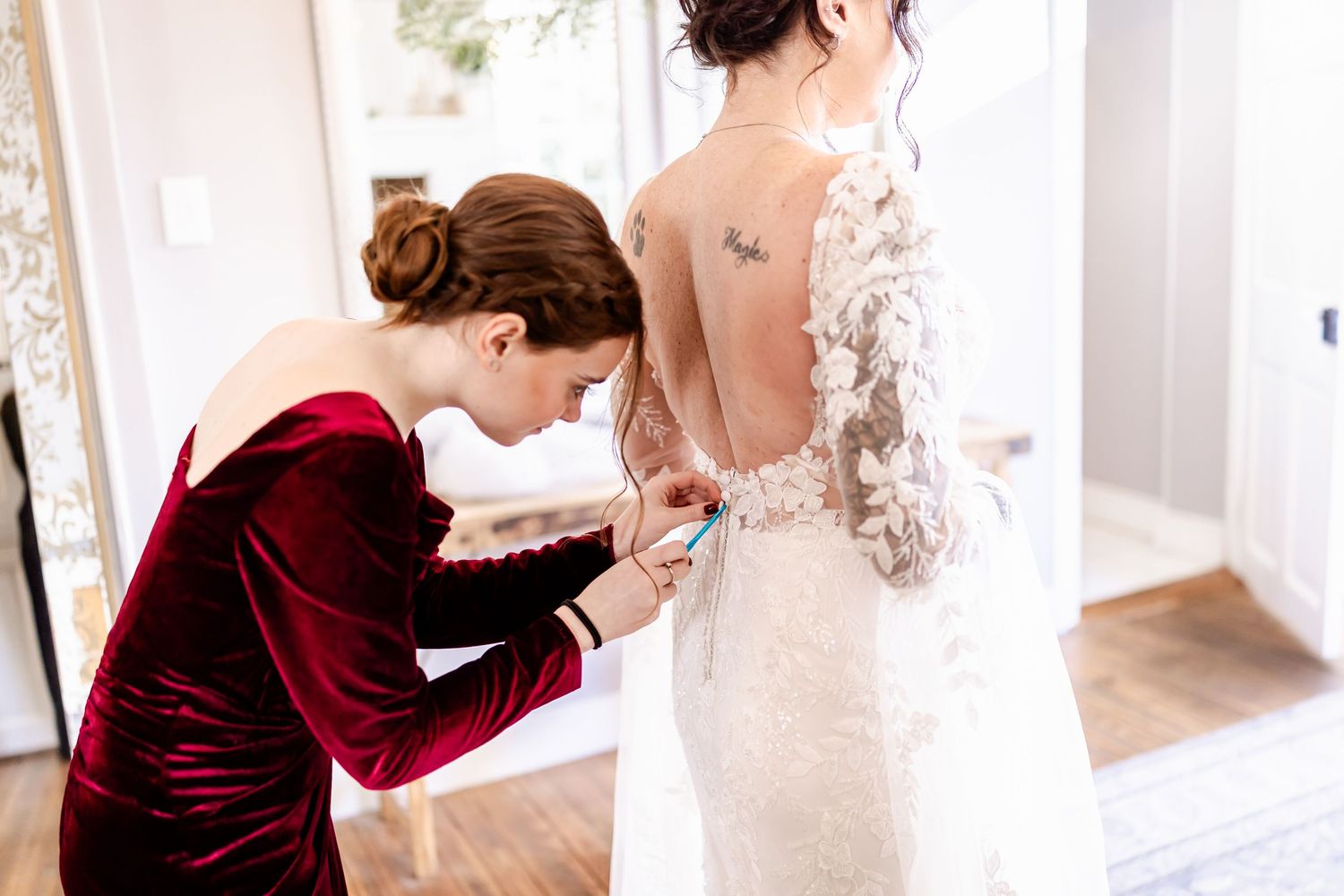 Bride and bridesmaids in burgundy velvet dresses prepare for a winter wedding celebration.