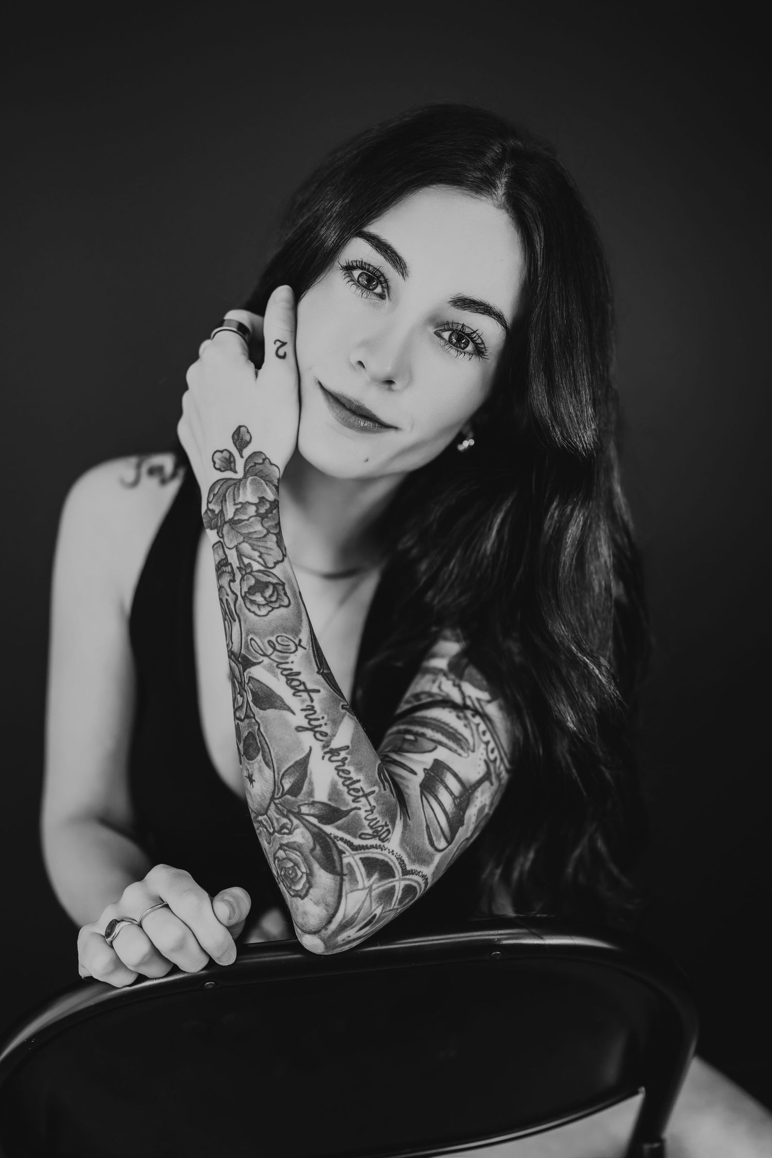 Black and white portraits showcasing intricate sleeve tattoos in dramatic lighting.