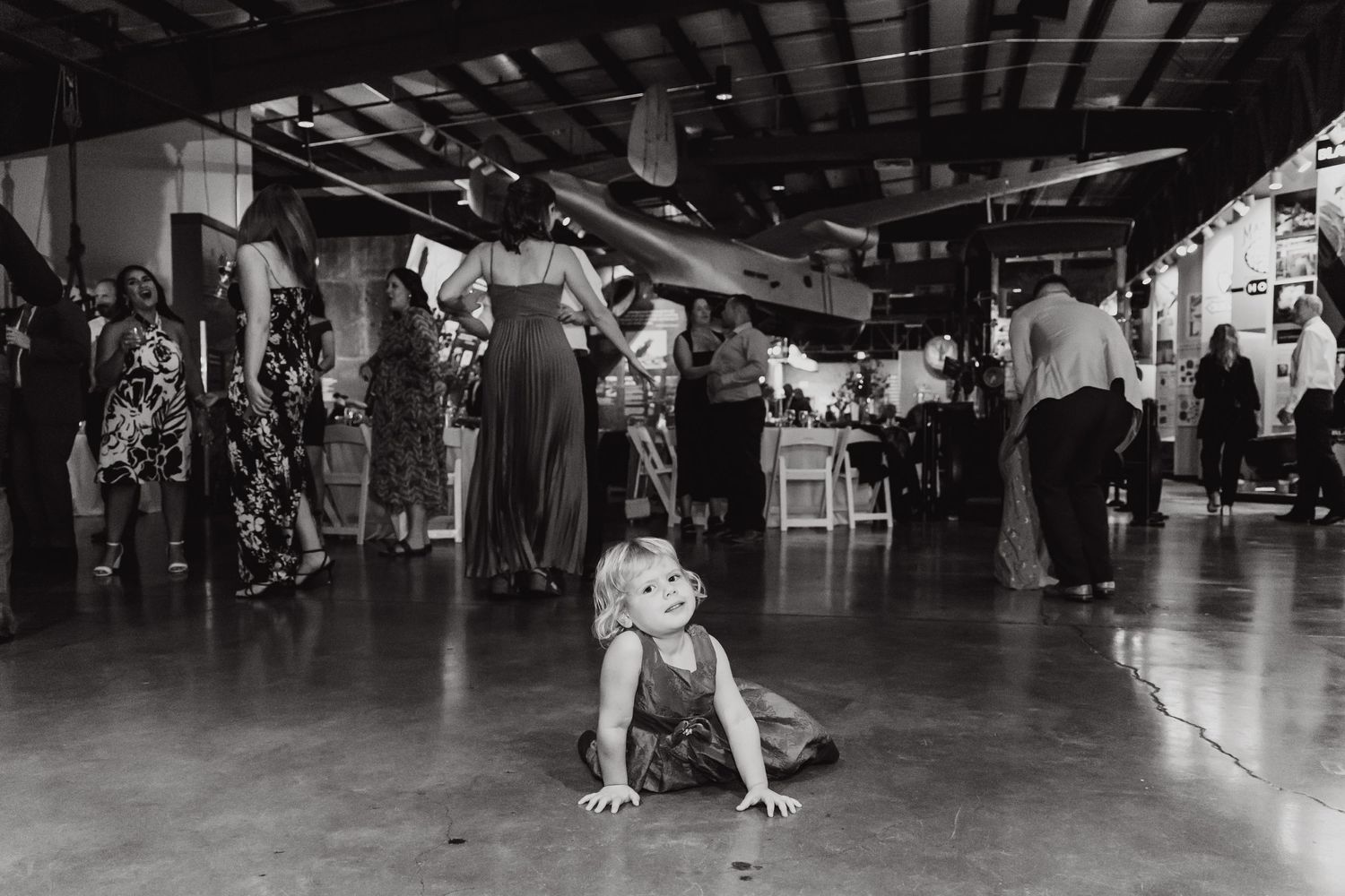 Black and white photo of wedding reception dance floor with guests dancing and mingling.
