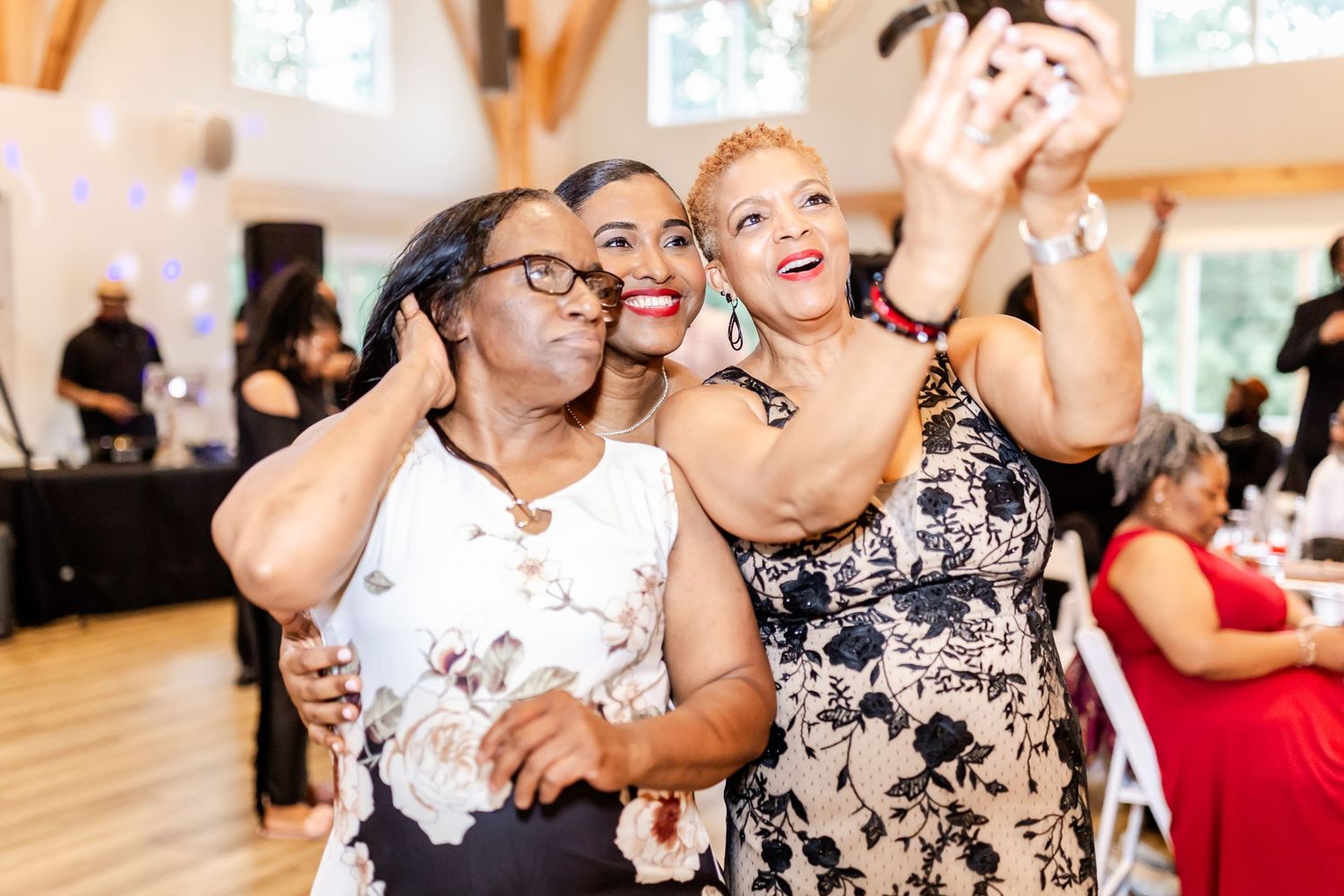 Party guests laughing and dancing together at a joyous celebration in a bright wooden hall.
