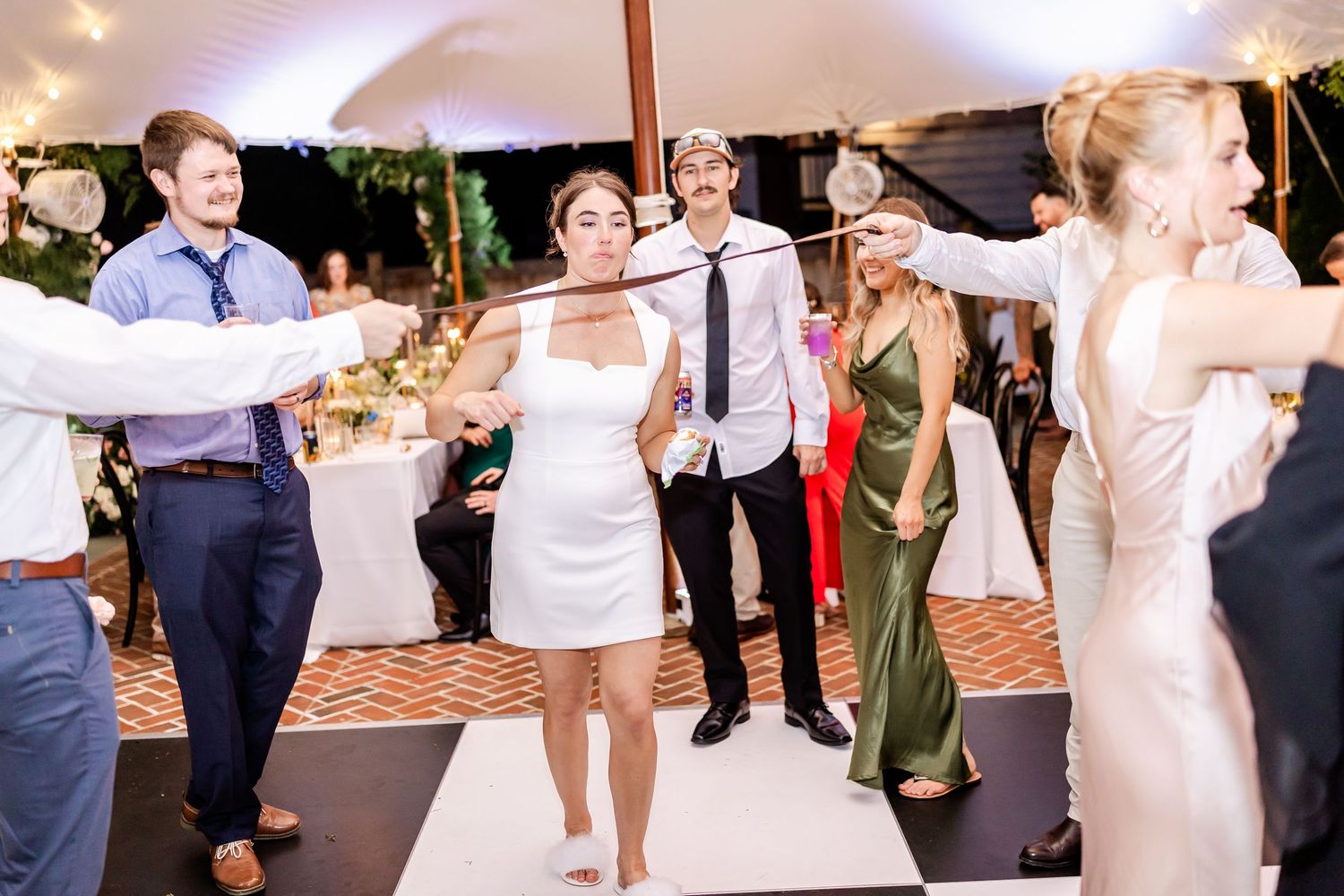 Wedding guests dancing and celebrating on a lively dance floor during the reception.