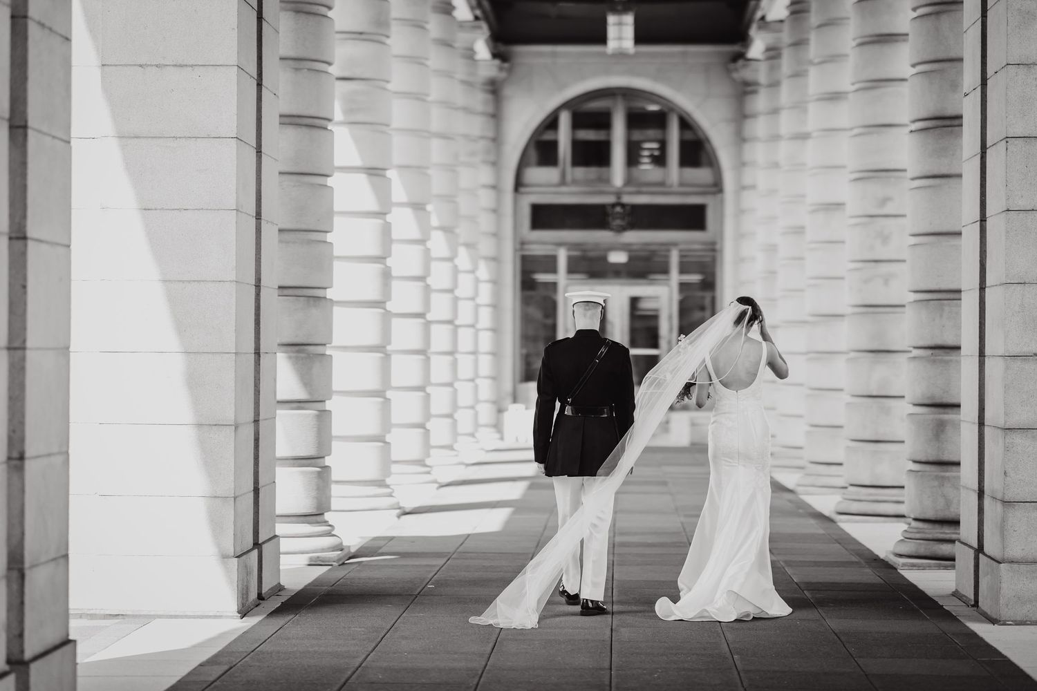 Elegant black and white architectural shot of a wedding venue with columns and arches.
