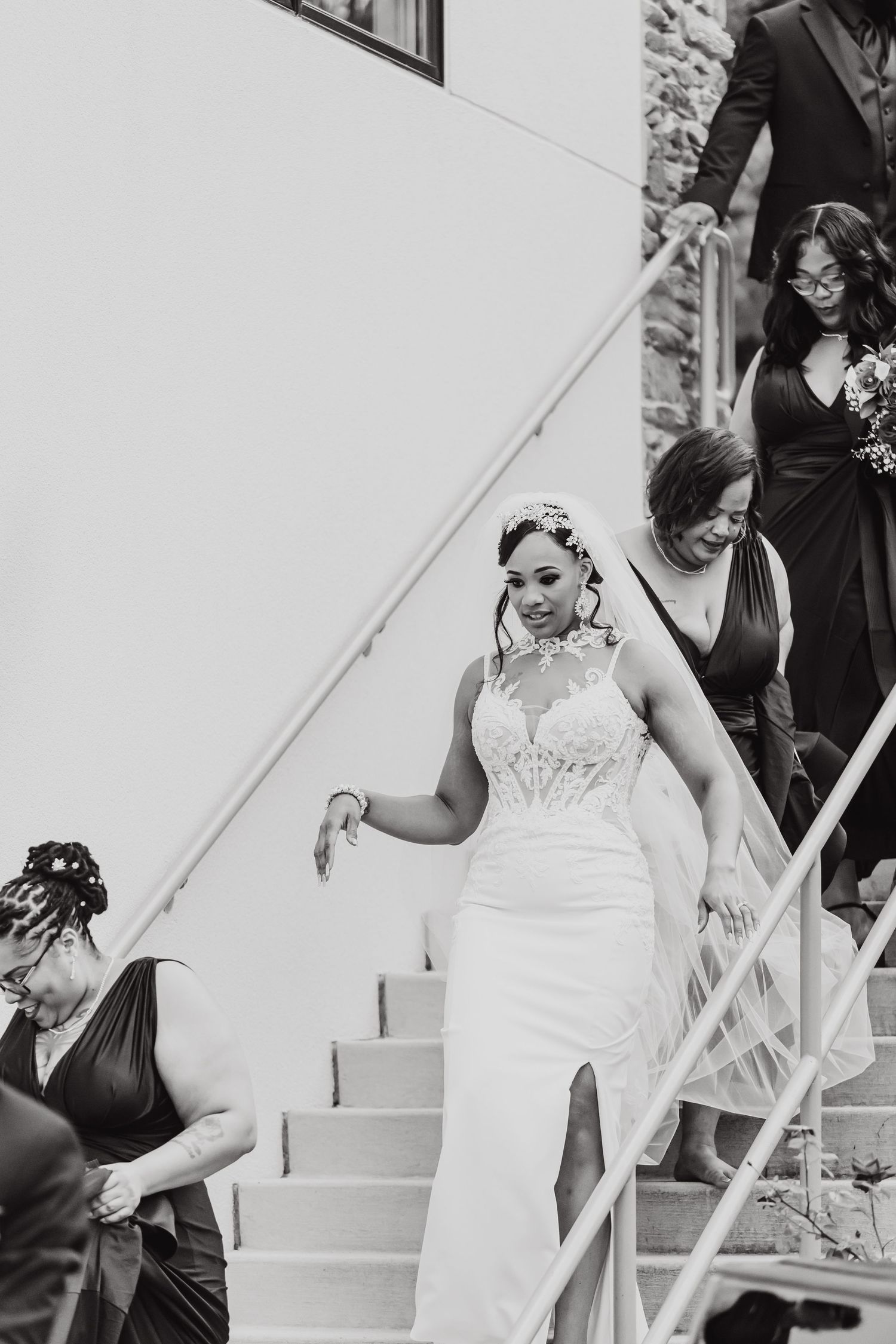 People in formal attire descending white outdoor stairs.