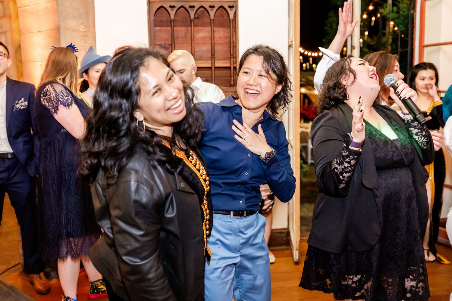 Party guests dancing and celebrating with enthusiasm in an elegantly decorated room.