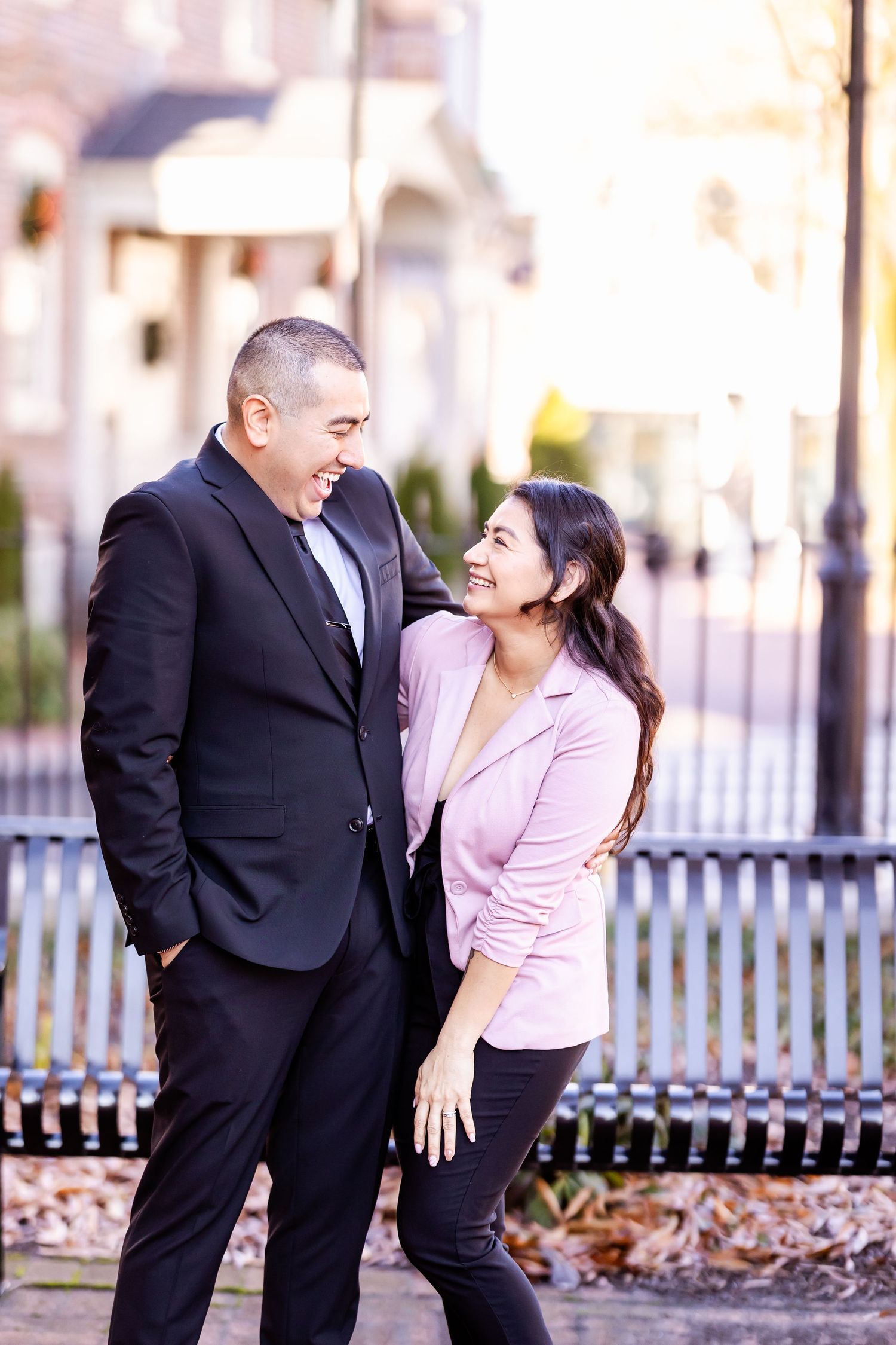 Couple sharing a lighthearted moment together in formal attire outdoors.