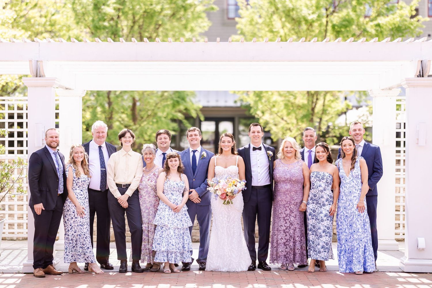 Wedding party members lined up outdoors for formal group portraits.