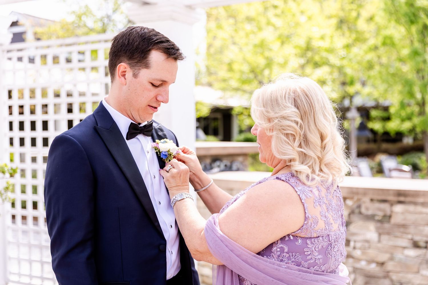 Outdoor wedding dance moment captured against garden lattice background.